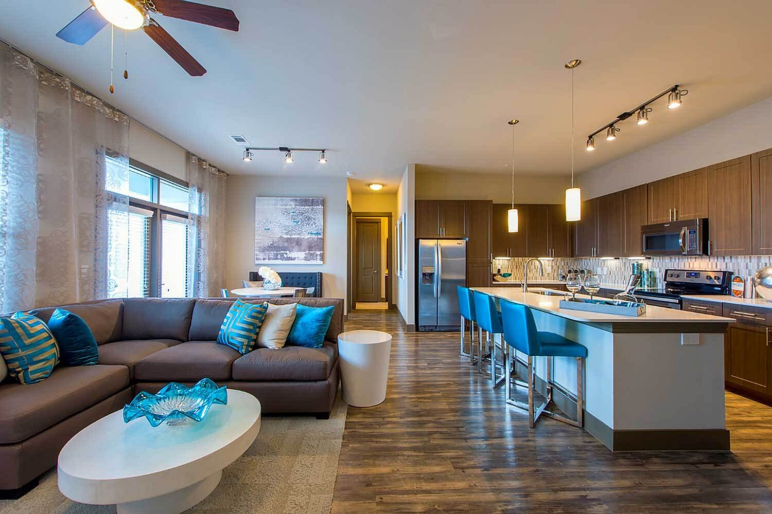 Elegant open-concept living area with modern kitchen, stylish bar seating, and cozy sectional sofa.