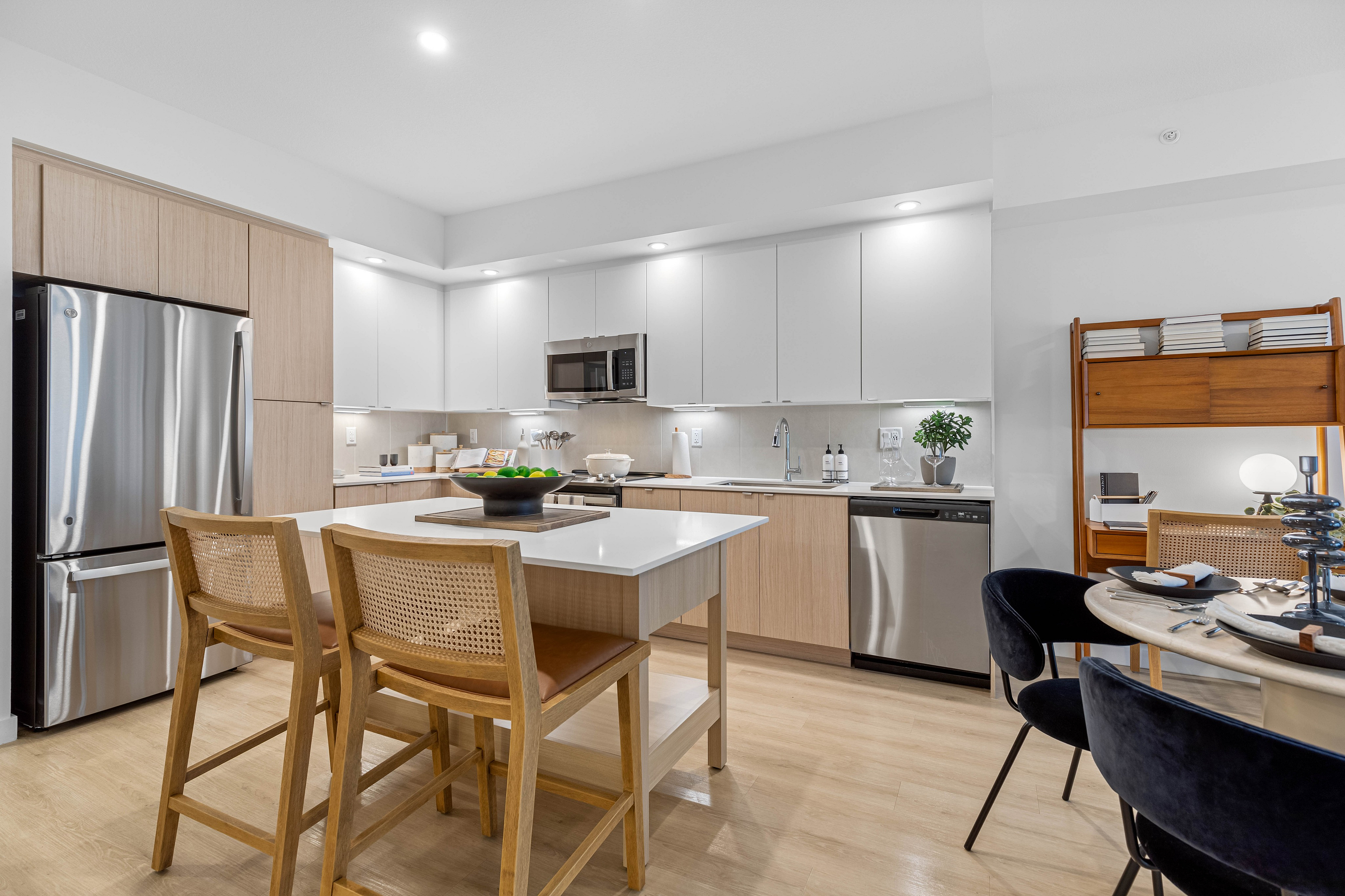 Contemporary kitchen with sleek stainless steel appliances, stylish island seating, and elegant dining area.