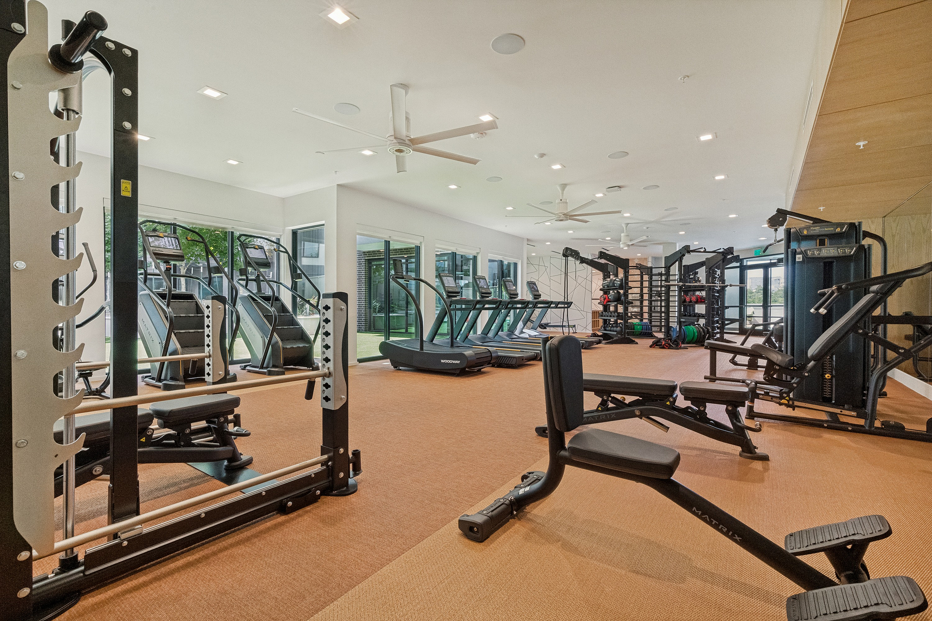Modern, well-equipped gym with state-of-the-art fitness machines and ample natural light, perfect for an active lifestyle.