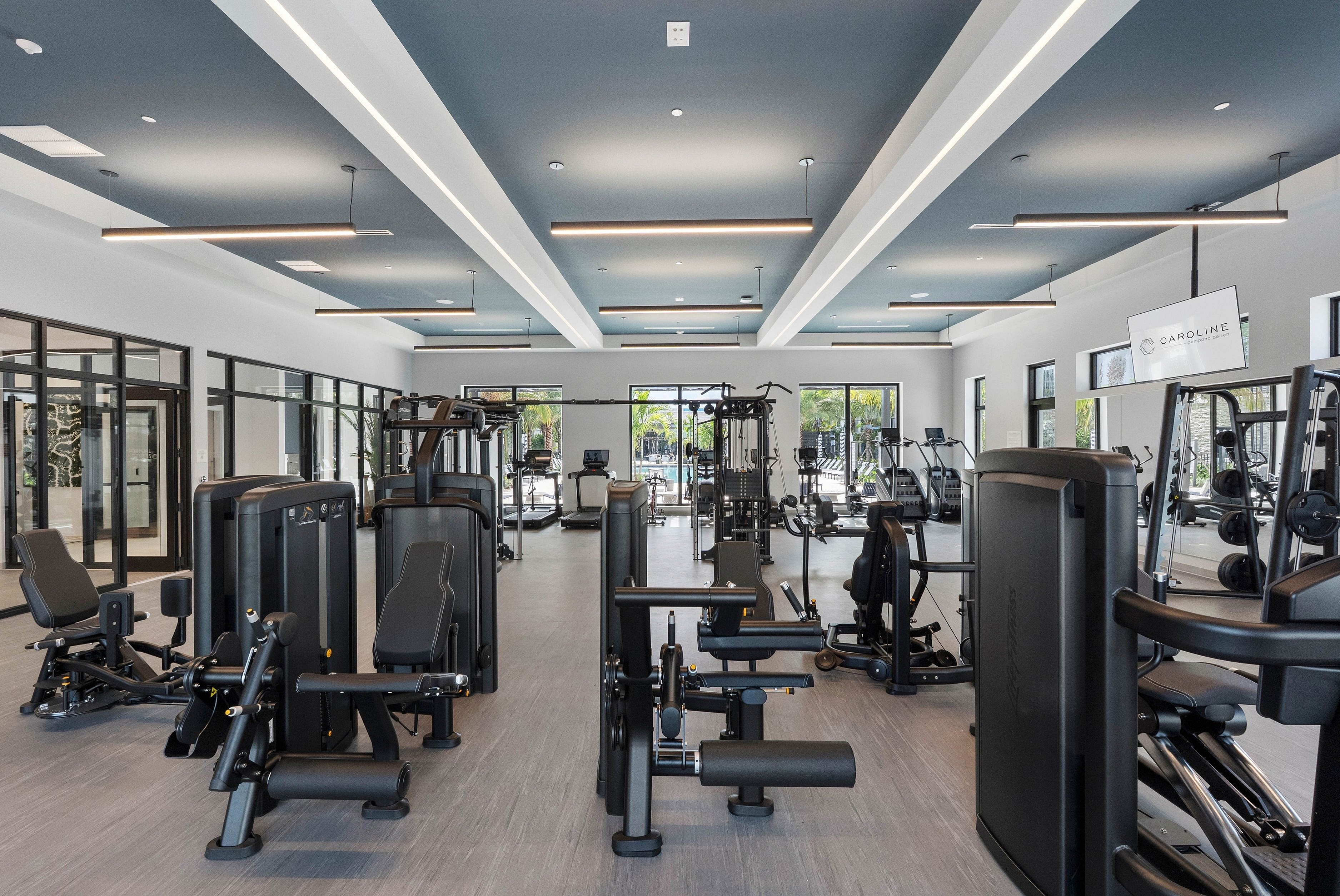 Modern fitness center featuring state-of-the-art gym equipment, sleek design, and natural lighting with outdoor views.