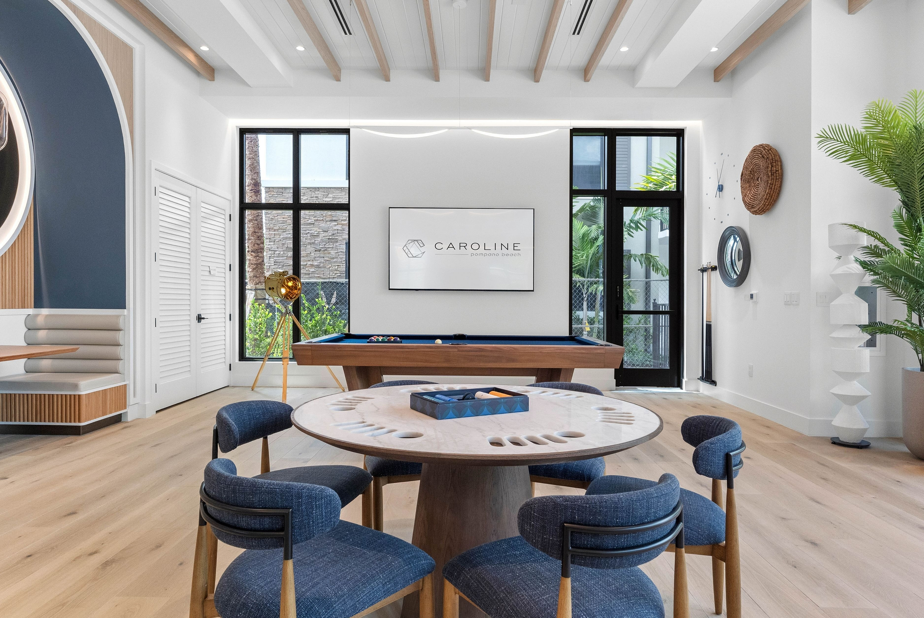 Chic and inviting game room featuring stylish seating, a sleek pool table, and modern decor in a bright, spacious setting.