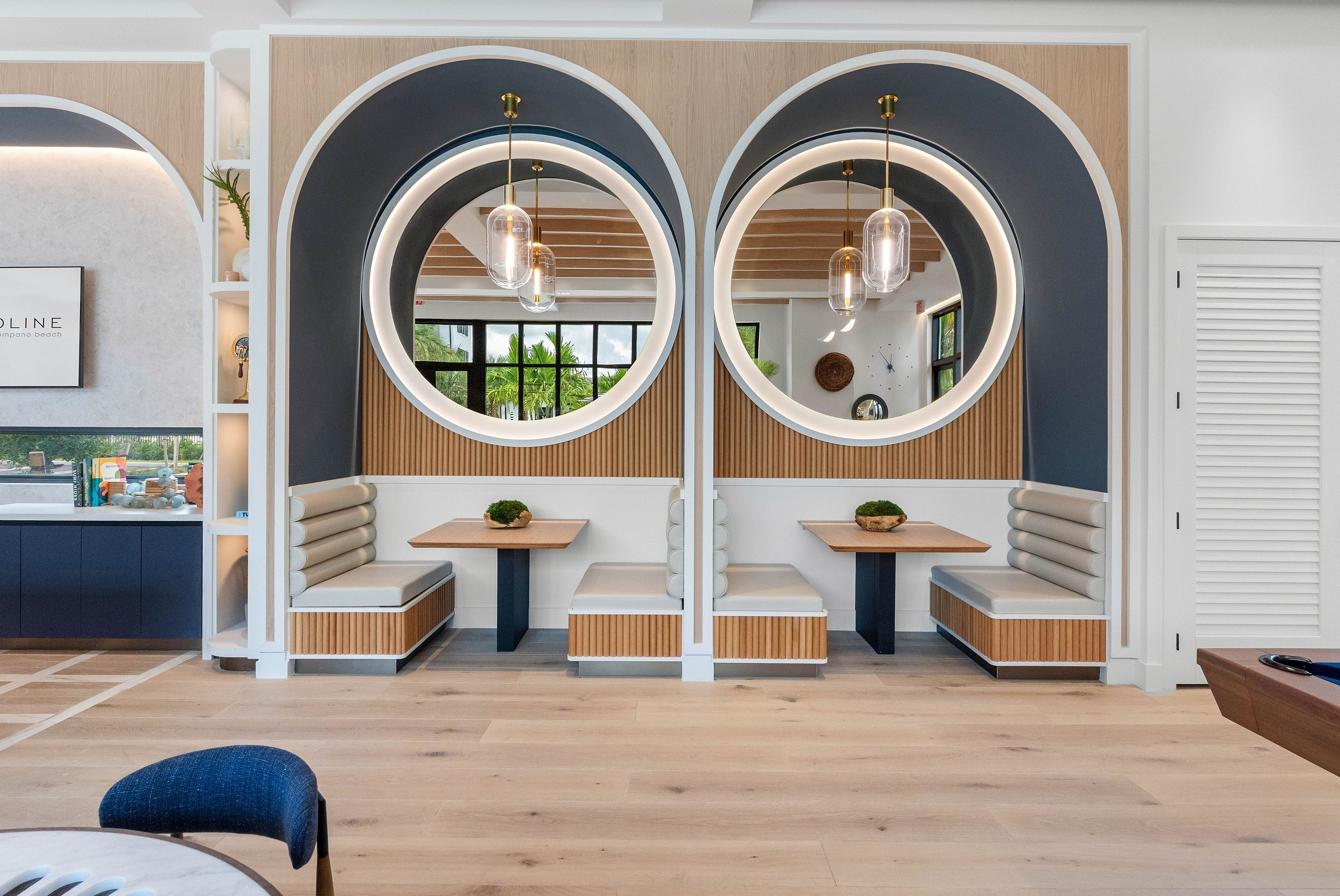 Chic and modern dining nook with elegant circular mirrors, plush seating, and stylish lighting.