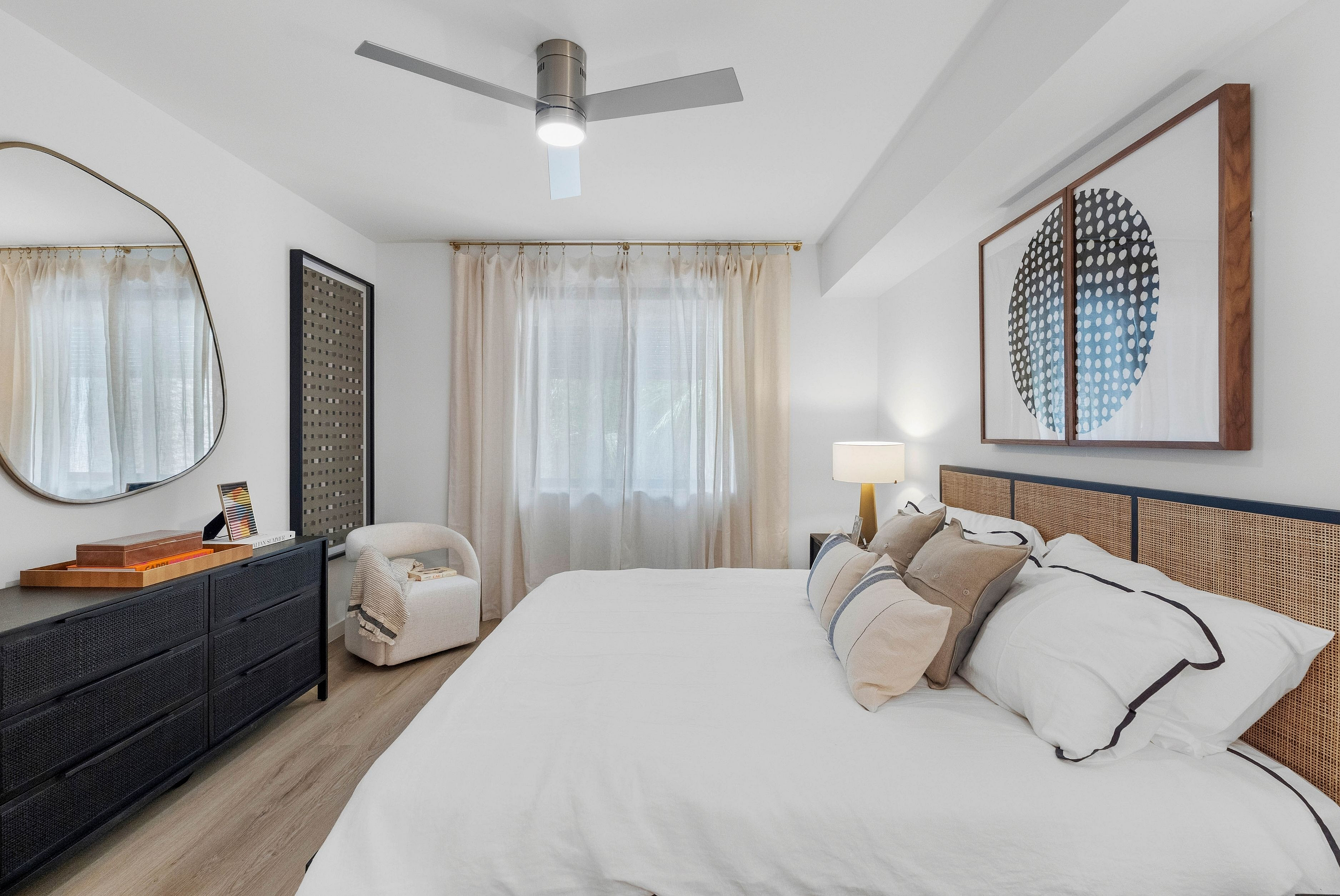 Chic bedroom with modern decor, featuring a comfortable bed with stylish pillows, soft ambient lighting, and elegant artwork. A serene space ideal for relaxation.
