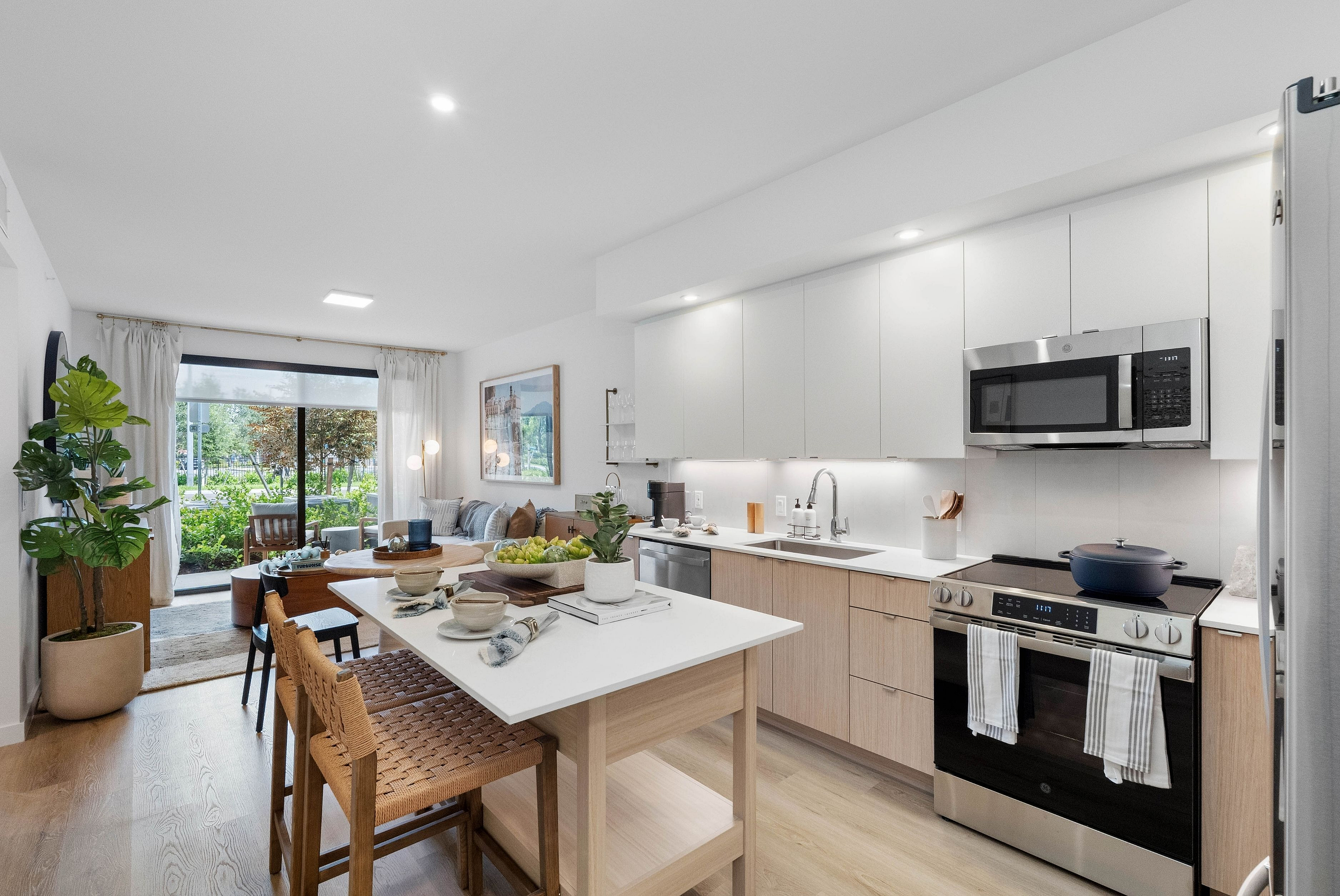 Modern open-concept kitchen and living area with sleek cabinetry, natural light, and stylish decor.