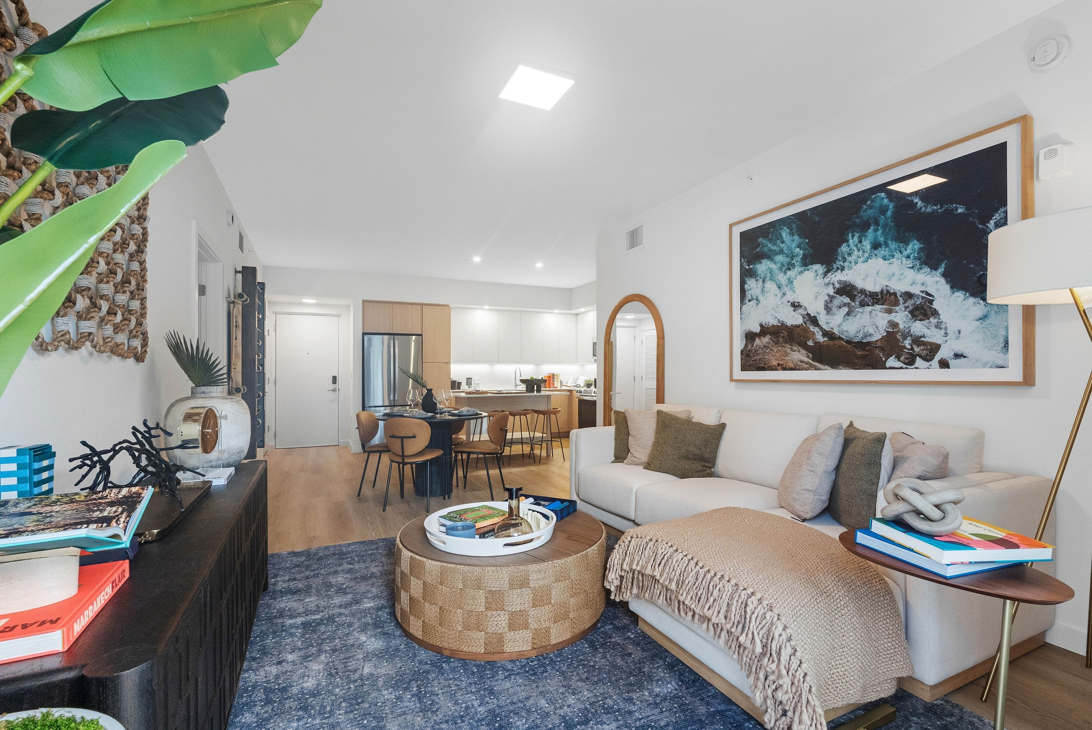 Contemporary living room with cozy sofa, stylish decor, and open-concept kitchen featuring modern amenities.
