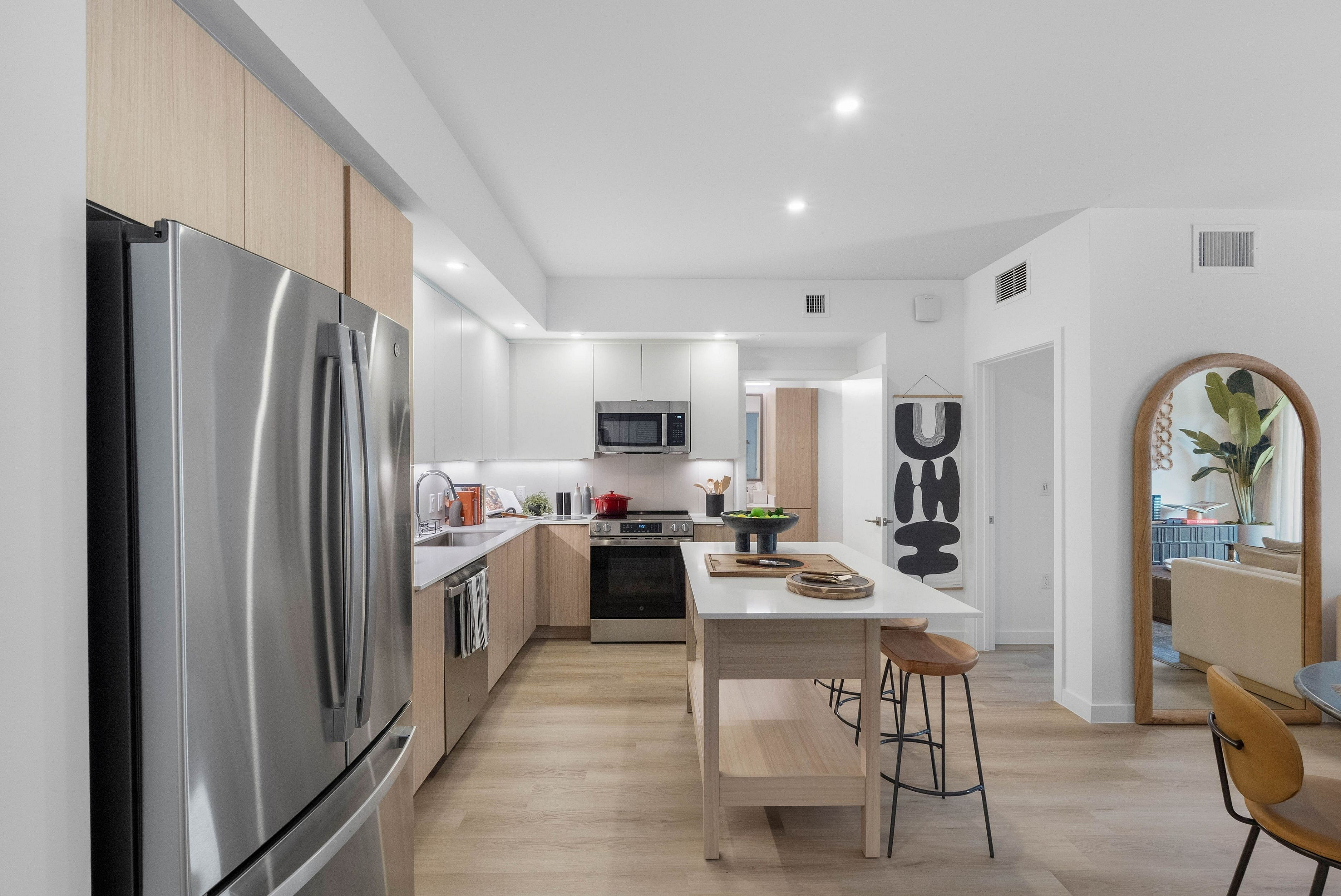 Modern kitchen with sleek stainless steel appliances, an inviting breakfast bar, and elegant wood finishes, perfect for culinary enthusiasts.