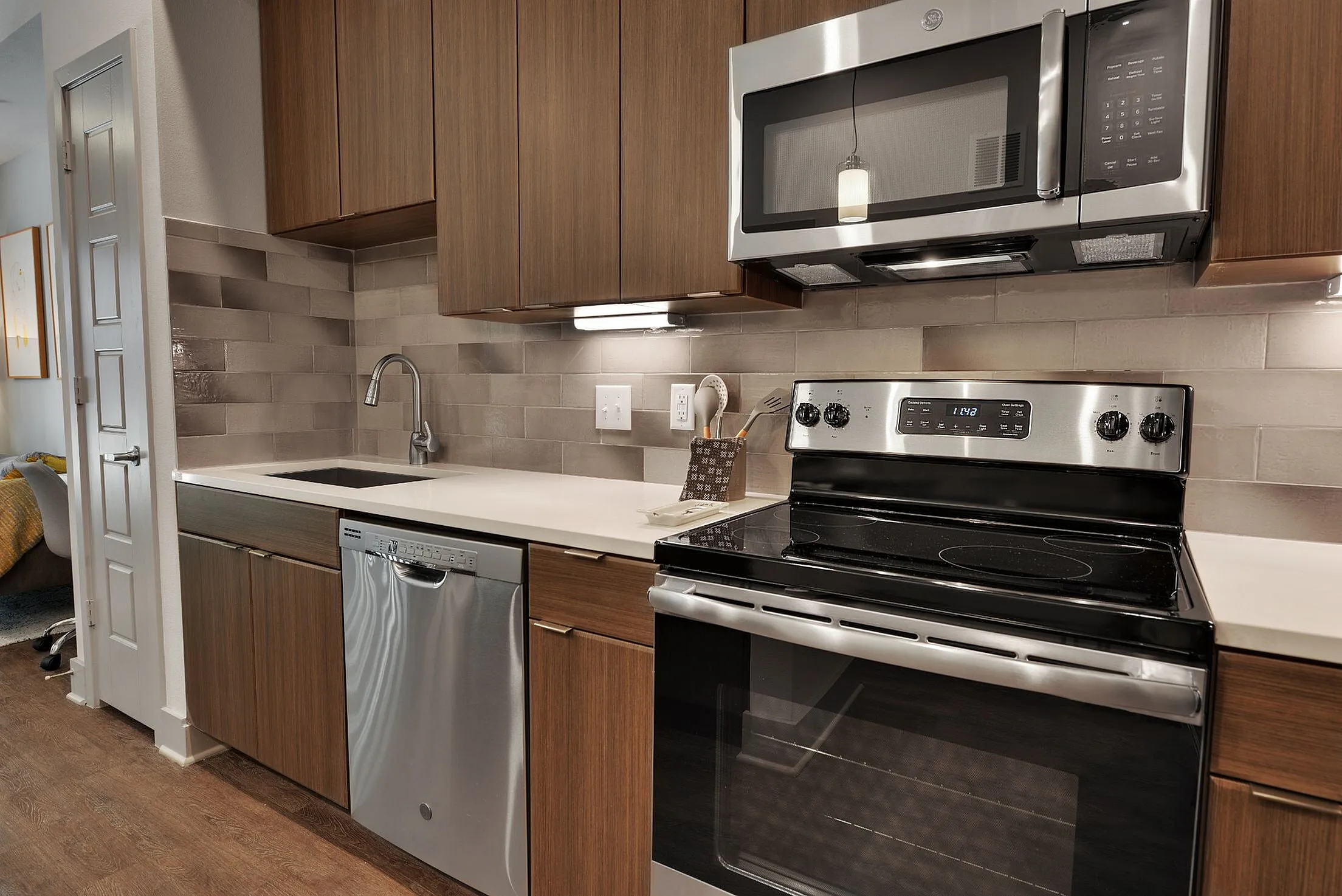 Kitchen with stainless range, microwave, dishwasher and tile backsplash