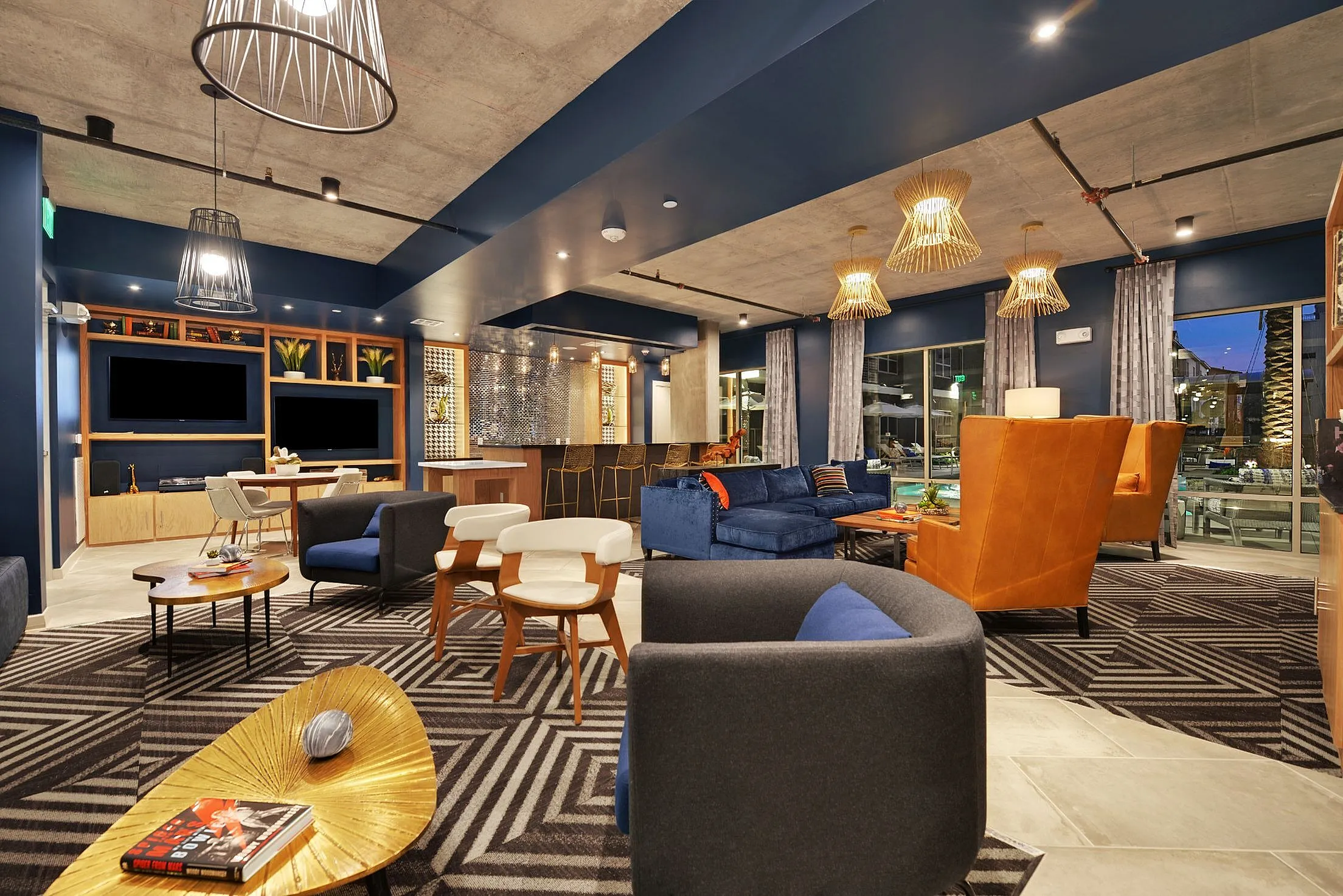 Clubhouse lounge with sofas, armchairs, TV and pendant lights
