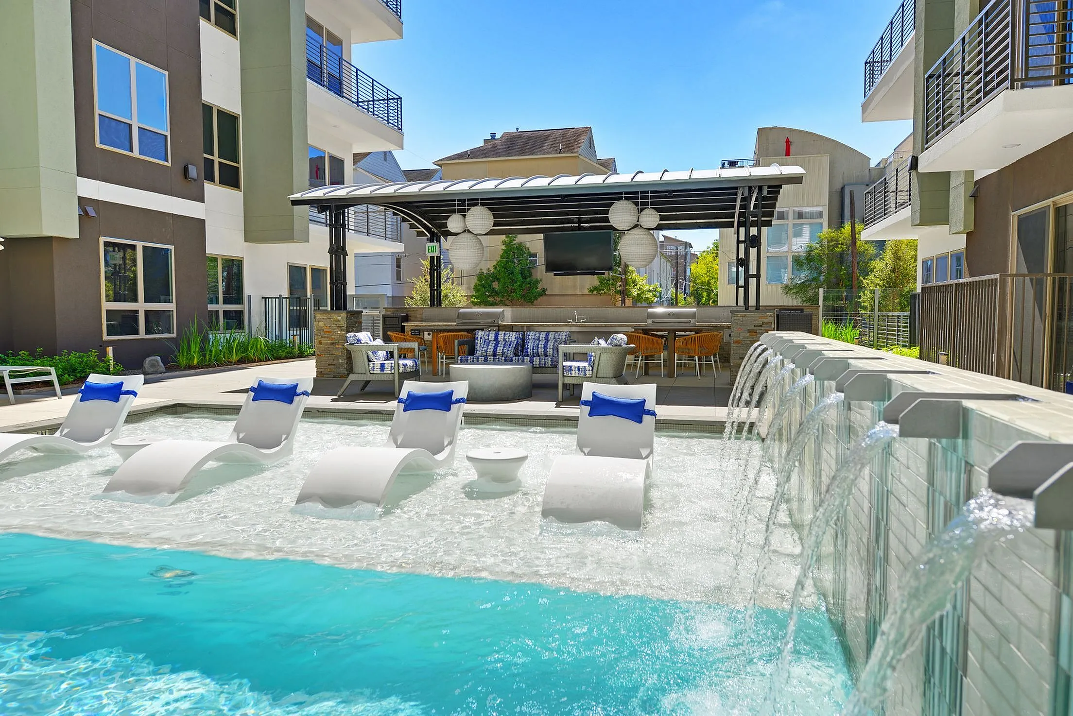 Pool sun shelf with lounge chairs, waterfall wall and cabana, Houston, TX