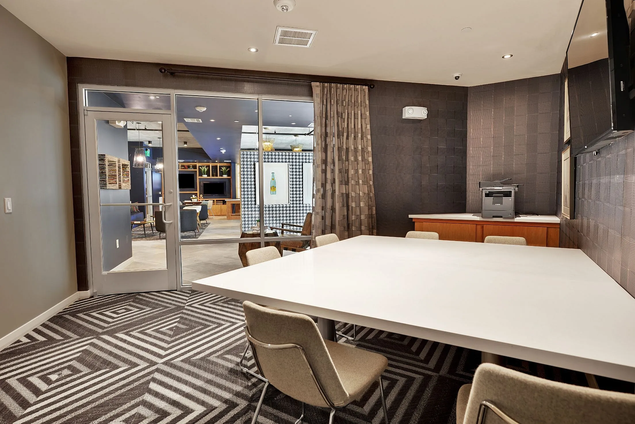 Conference room with work table, chairs and glass doors to the clubhouse