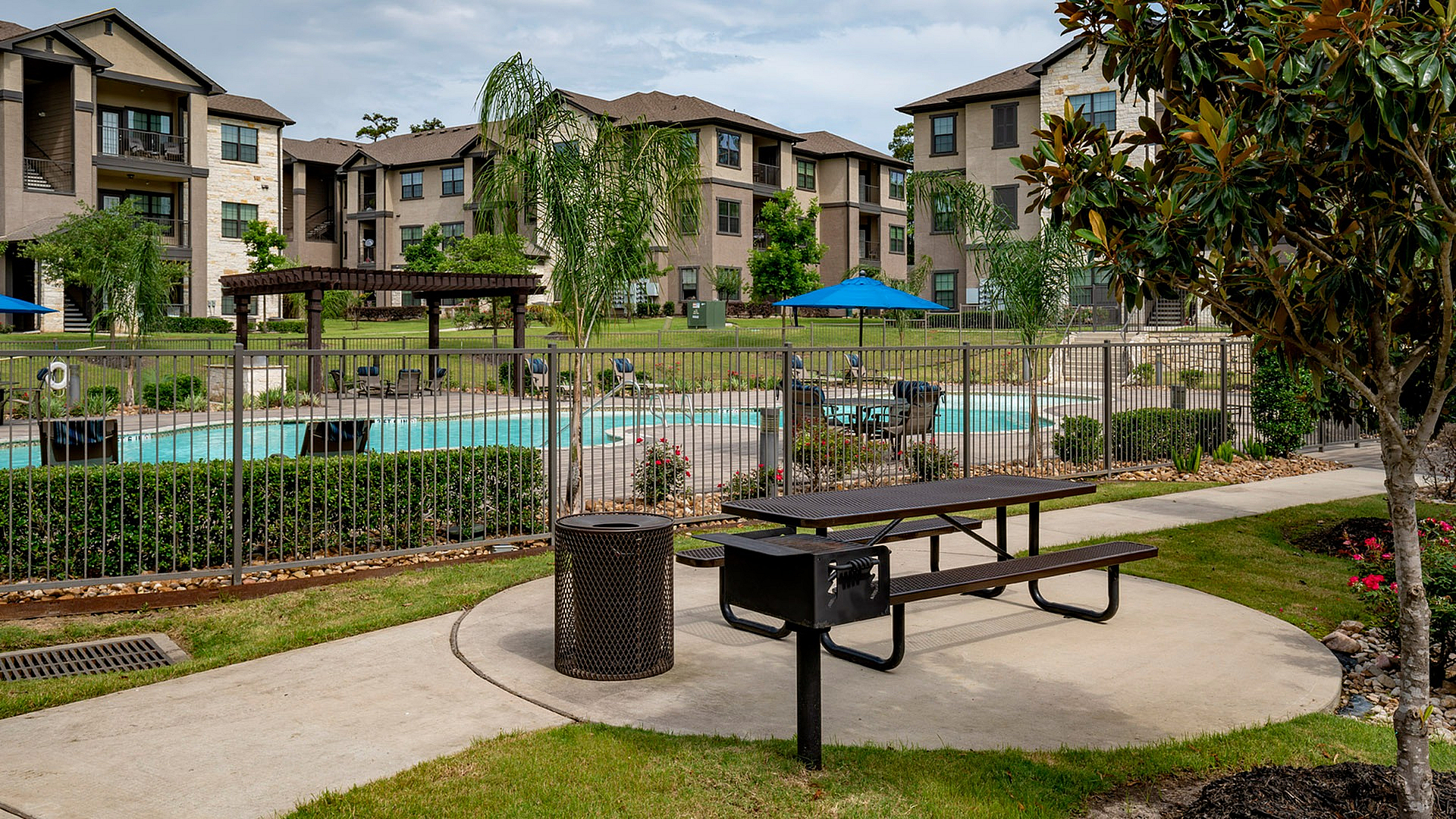 Charming apartment complex with lush landscaping and a sparkling pool, perfect for relaxing in style.