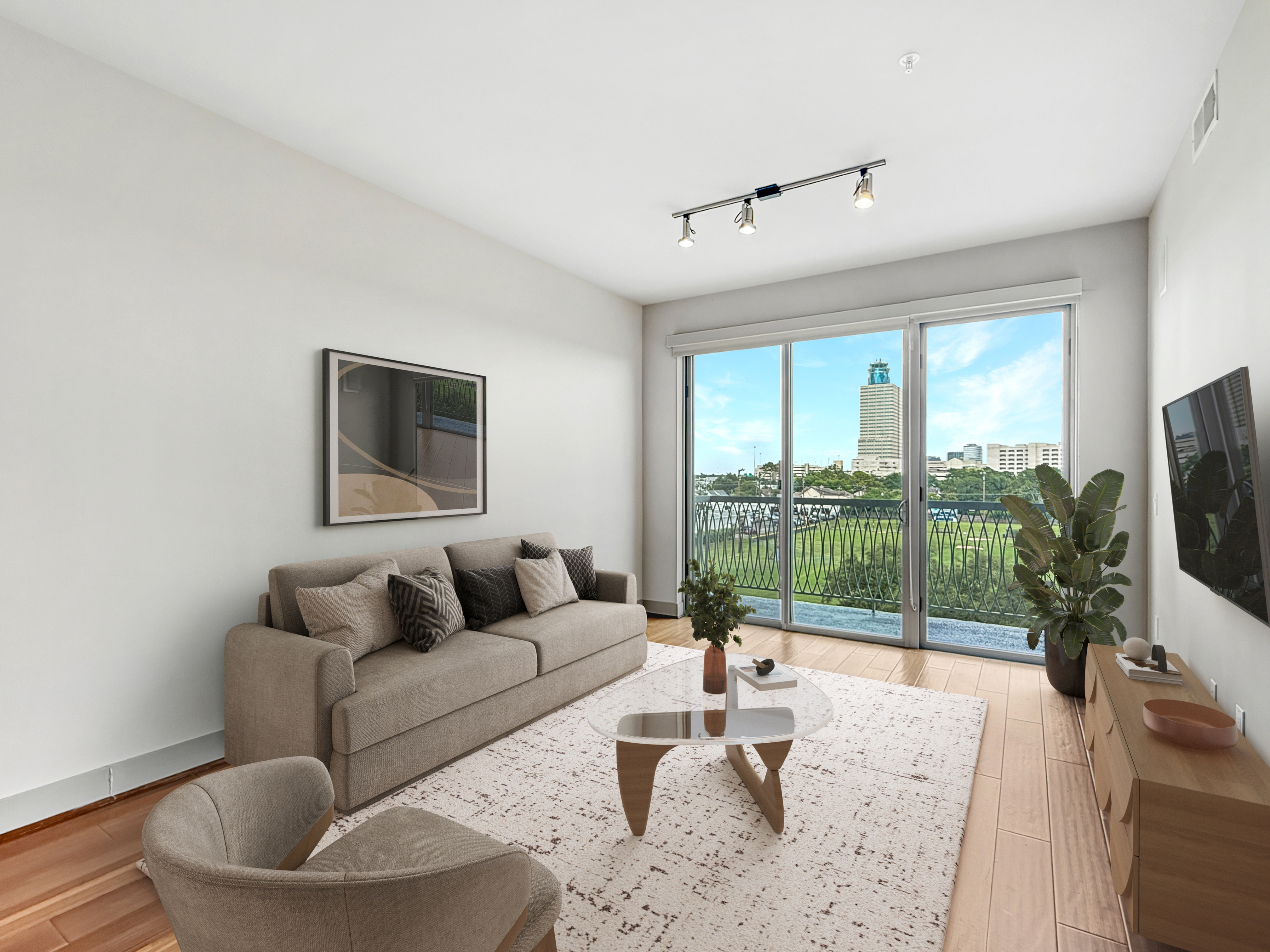 Bright and modern living room with comfortable sofa, chic decor, and large sliding glass doors offering a stunning city view.