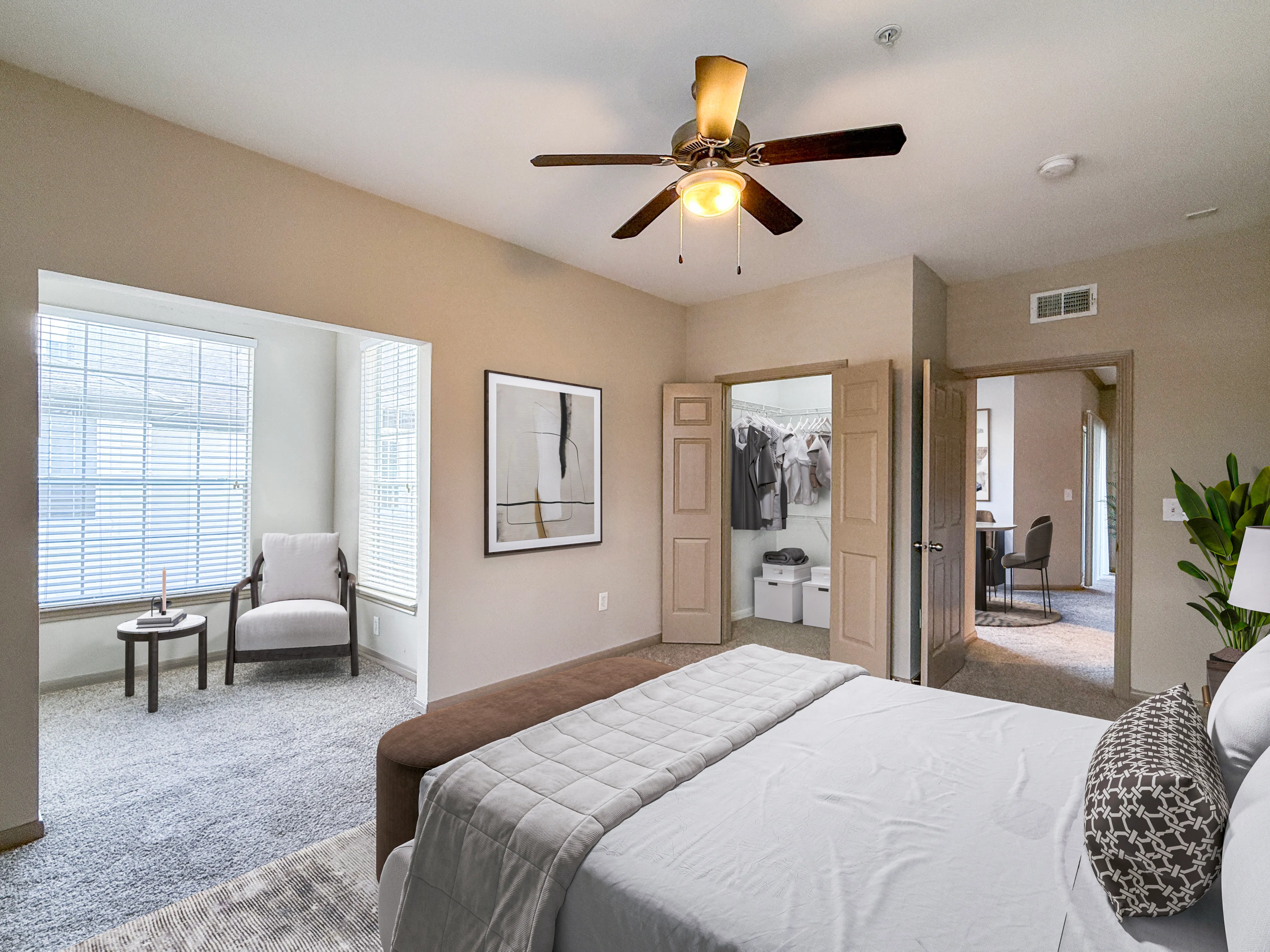 Elegant bedroom with cozy sitting area, large windows, and a spacious walk-in closet, ideal for a serene retreat.
