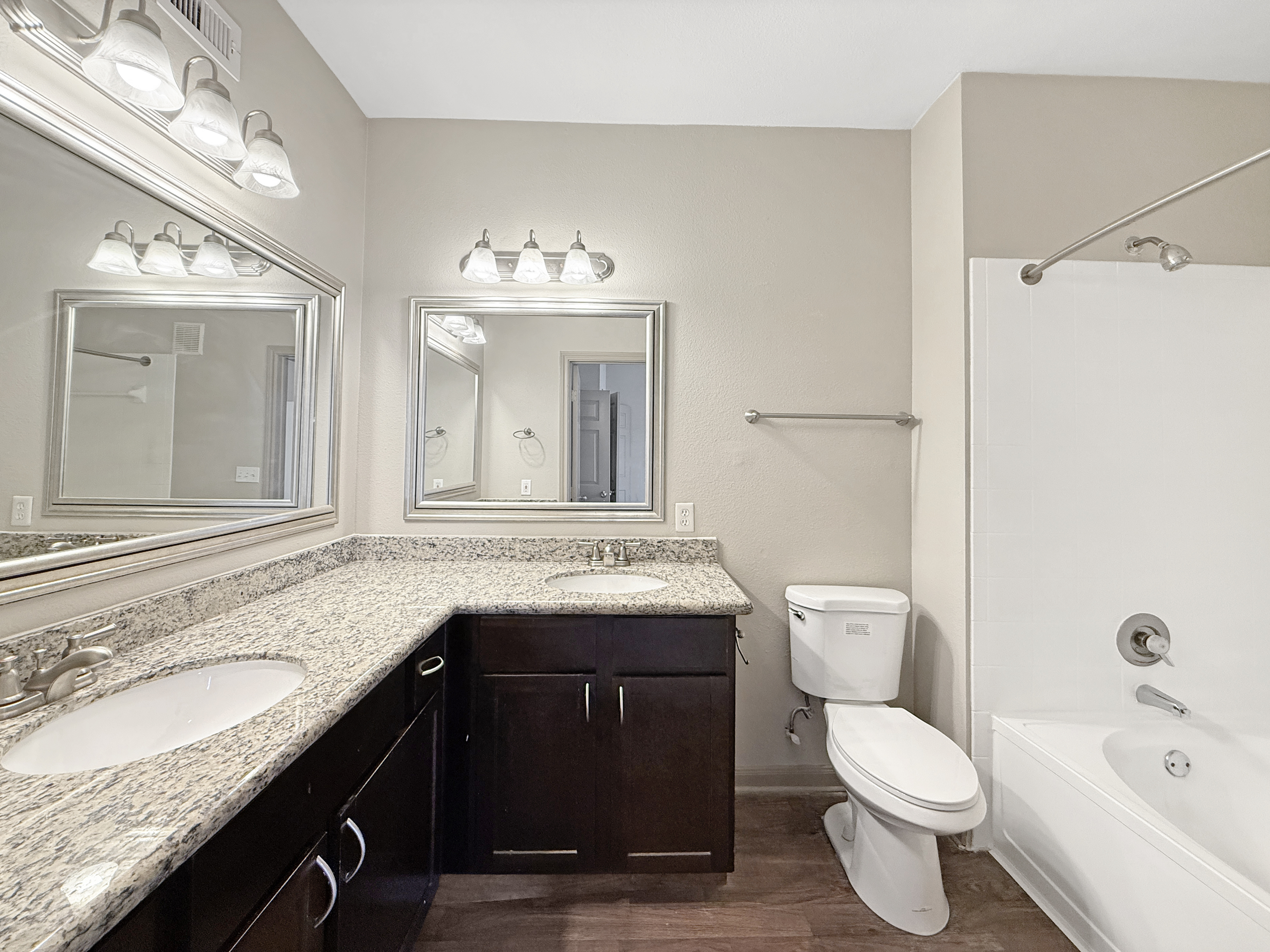 Luxurious bathroom featuring elegant granite countertops, dual sinks, and a pristine bathtub for a spa-like experience.