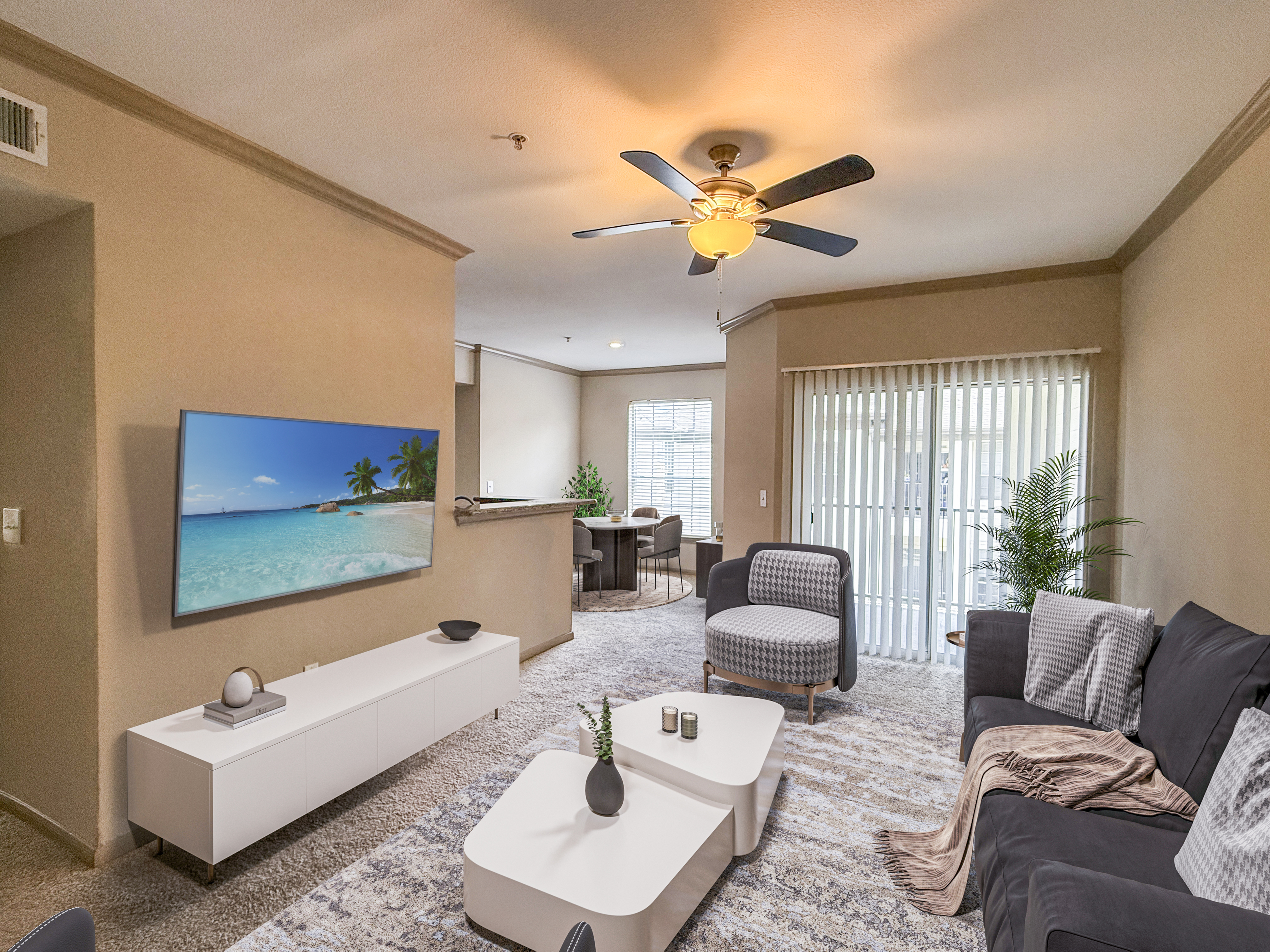 Inviting living room with modern decor, large windows, and sliding door opening to natural light. Features a cozy seating area and wall-mounted TV.