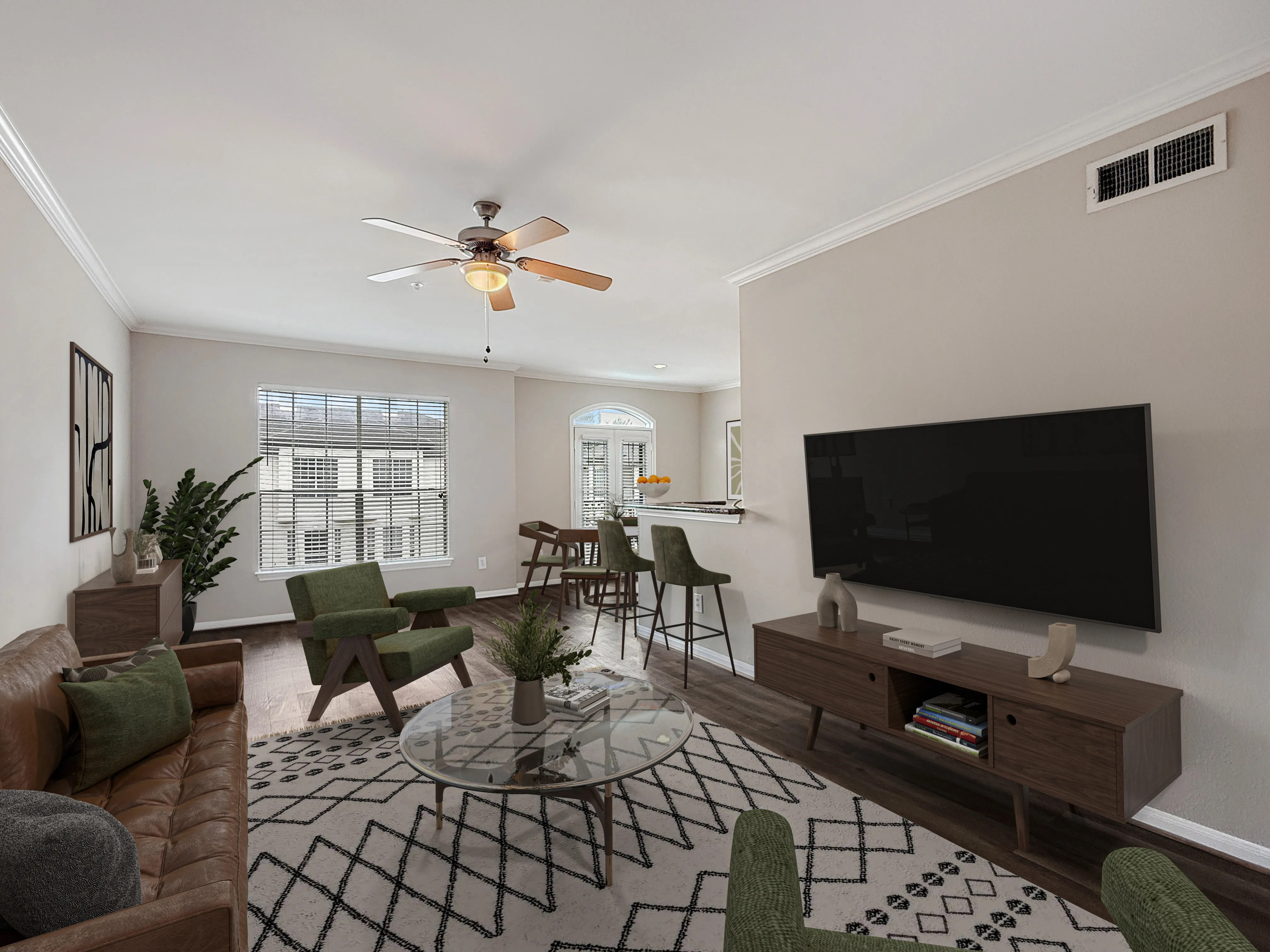 Inviting living room with modern decor, featuring a plush leather sofa, stylish green chairs, and a sleek mounted TV. The space is brightened by large windows and sophisticated lighting, offering a cozy yet elegant ambiance.