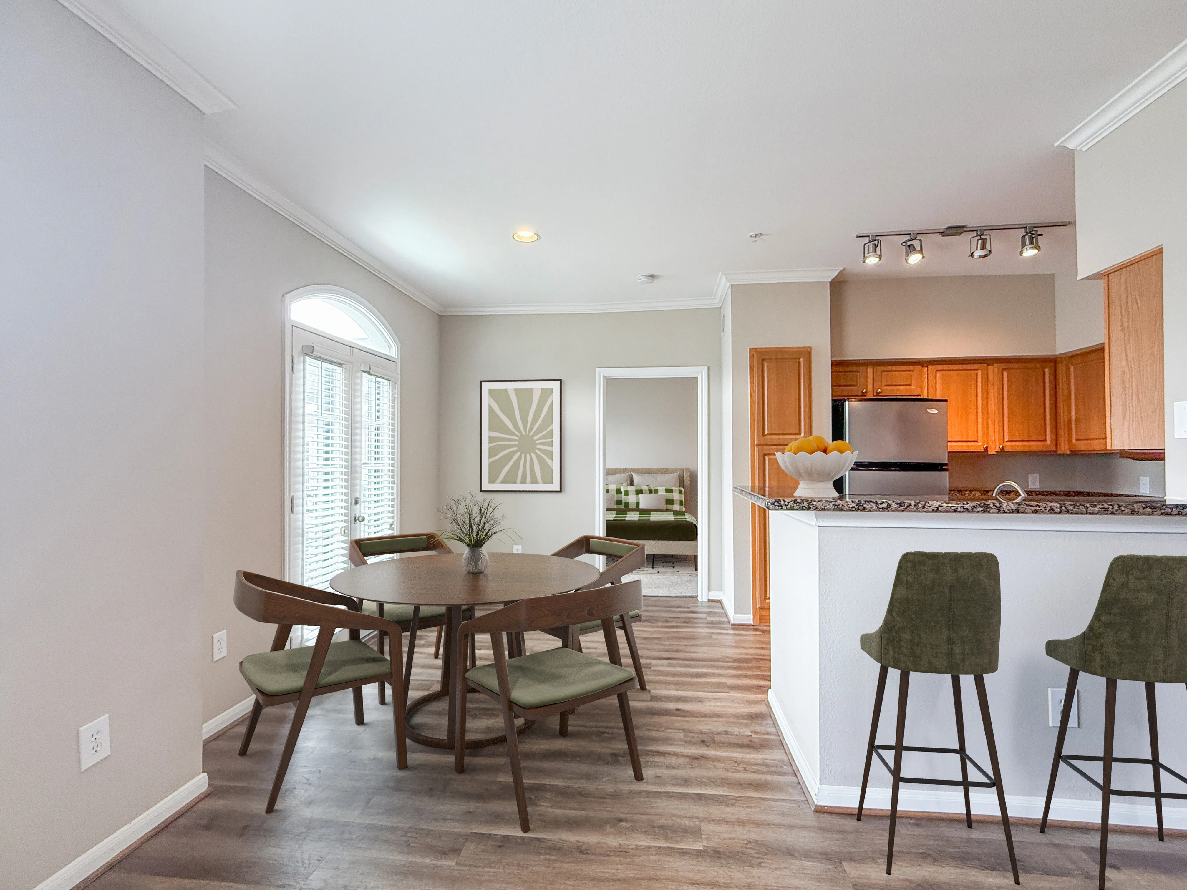Modern dining area with elegant wooden table and chairs, adjacent to a stylish kitchen with granite countertops and bar stools, enhanced by natural light through large windows.
