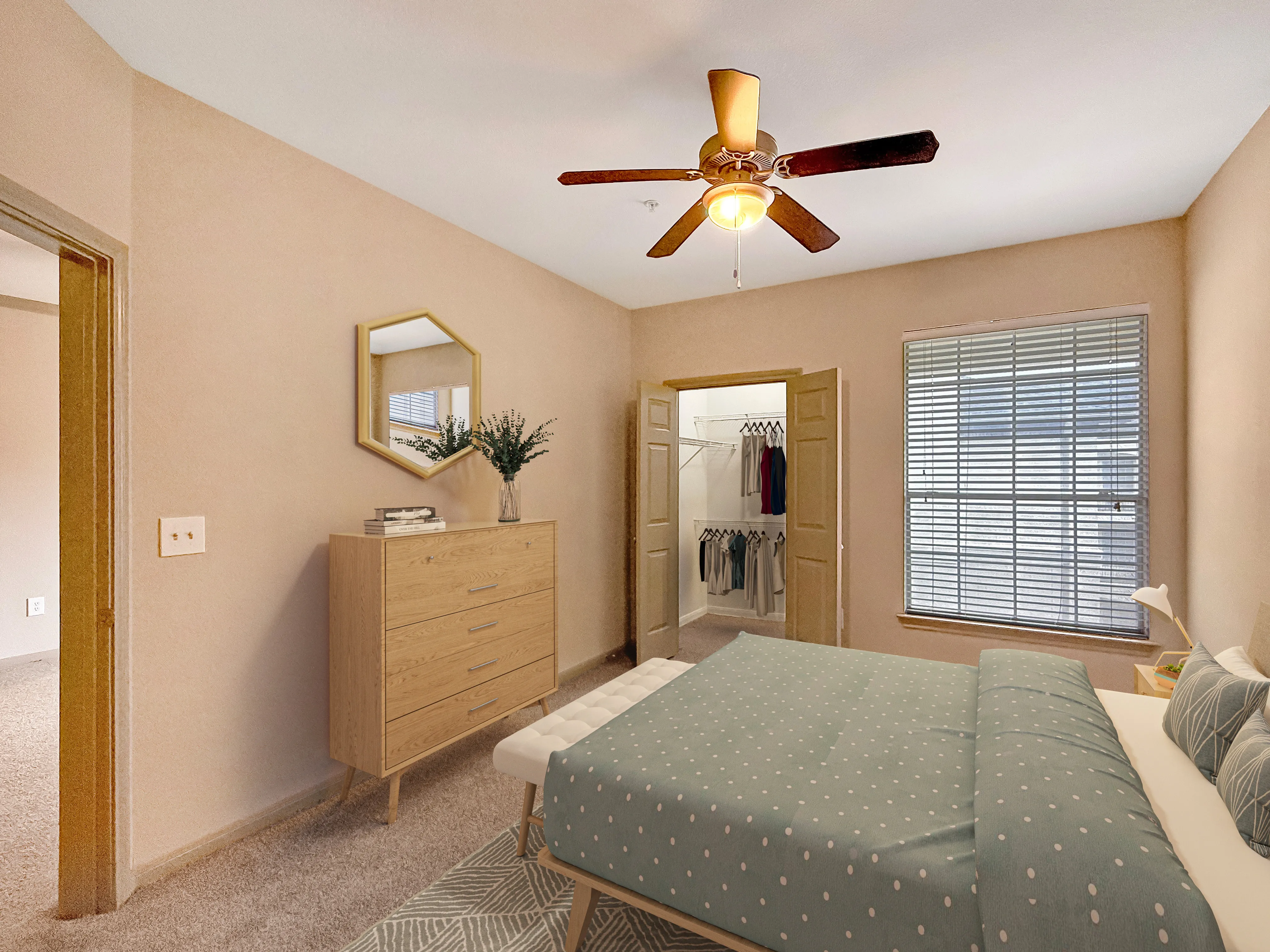 Cozy bedroom featuring a ceiling fan, elegant wooden dresser, and a walk-in closet with ample storage space.