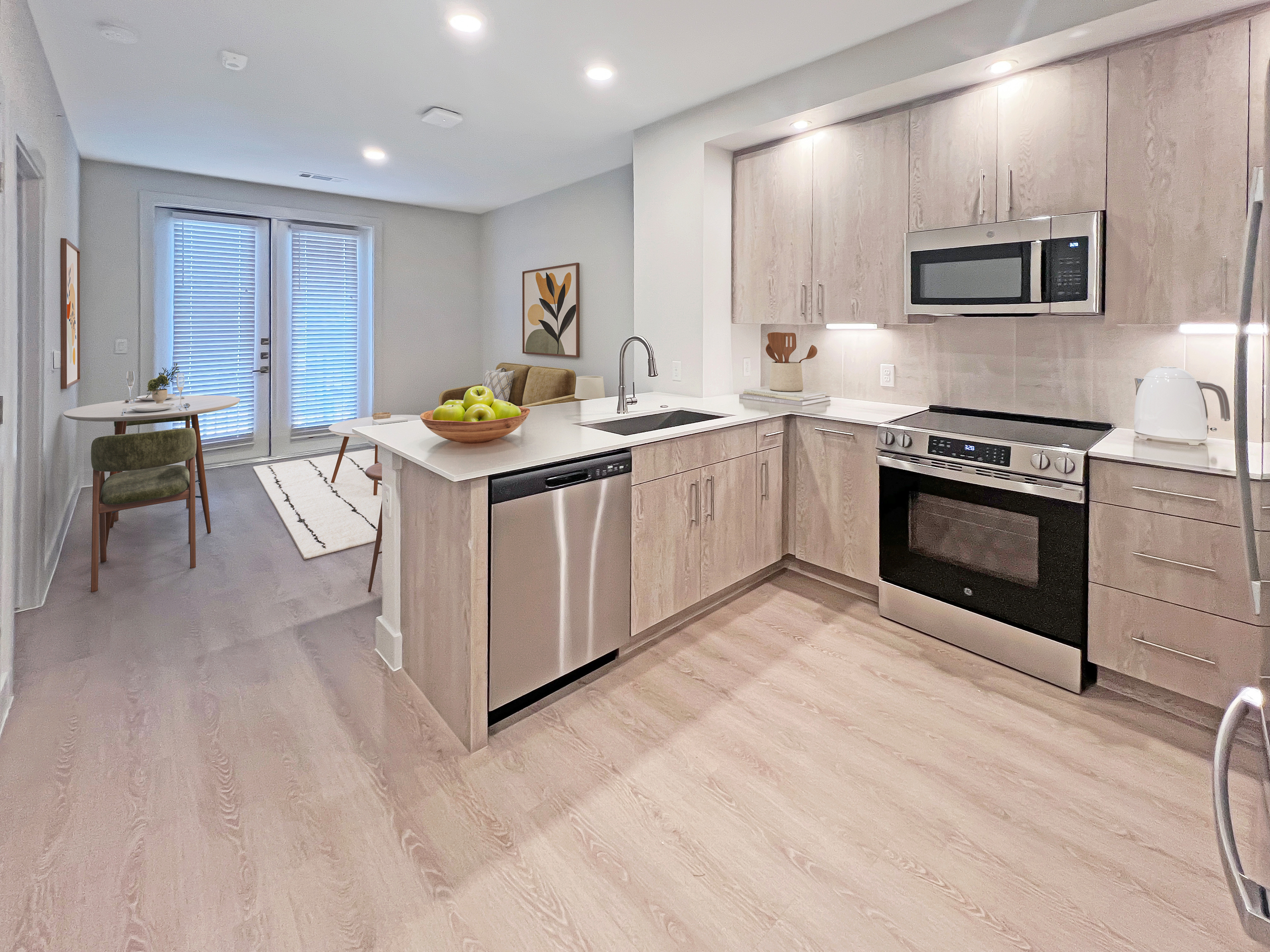 Bright and modern apartment kitchen with sleek cabinetry, stainless steel appliances, and an inviting dining area featuring stylish decor.