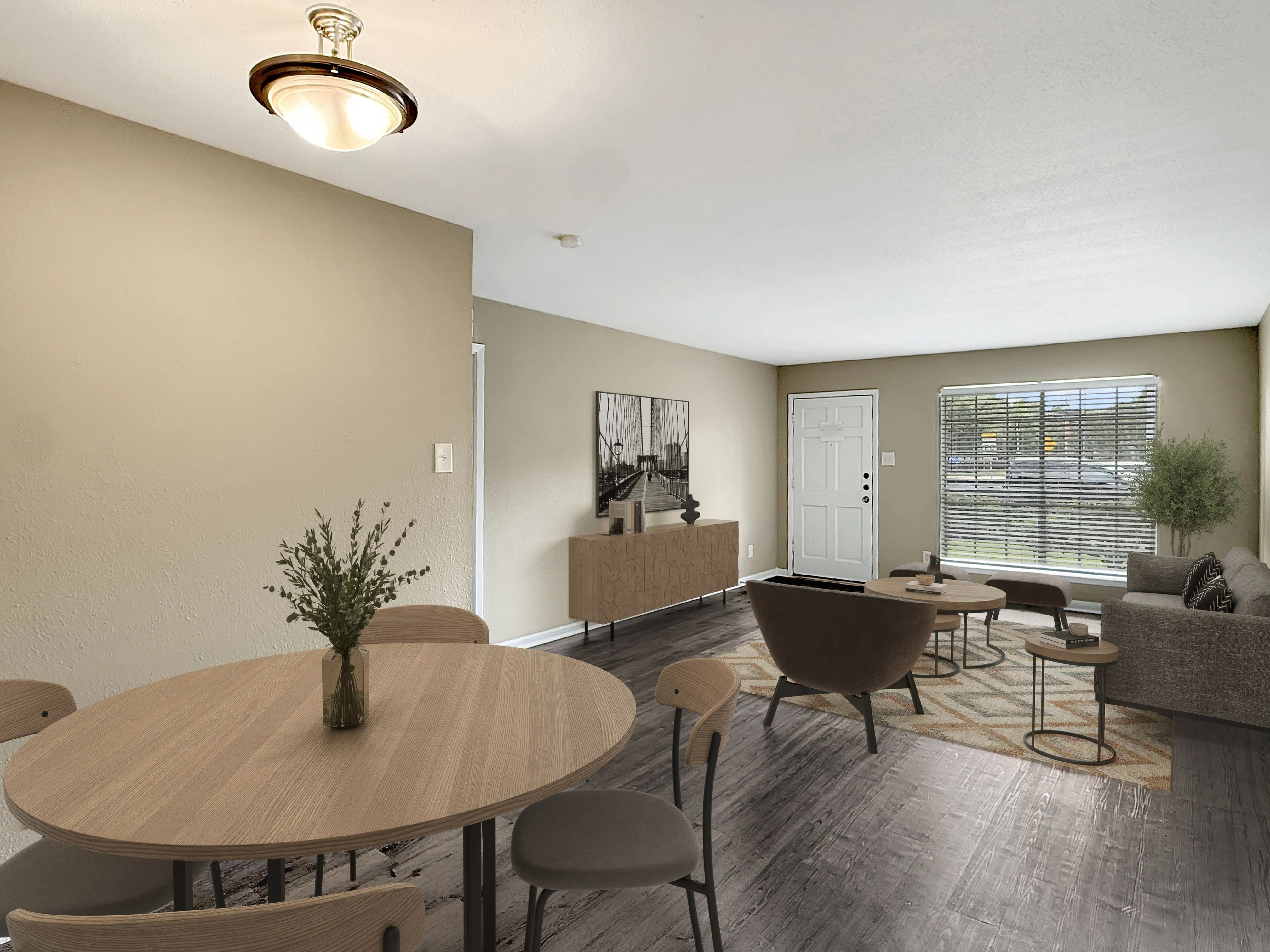 Inviting open-concept living room with contemporary decor, featuring a cozy seating area, round wooden dining table, and large window for natural light.