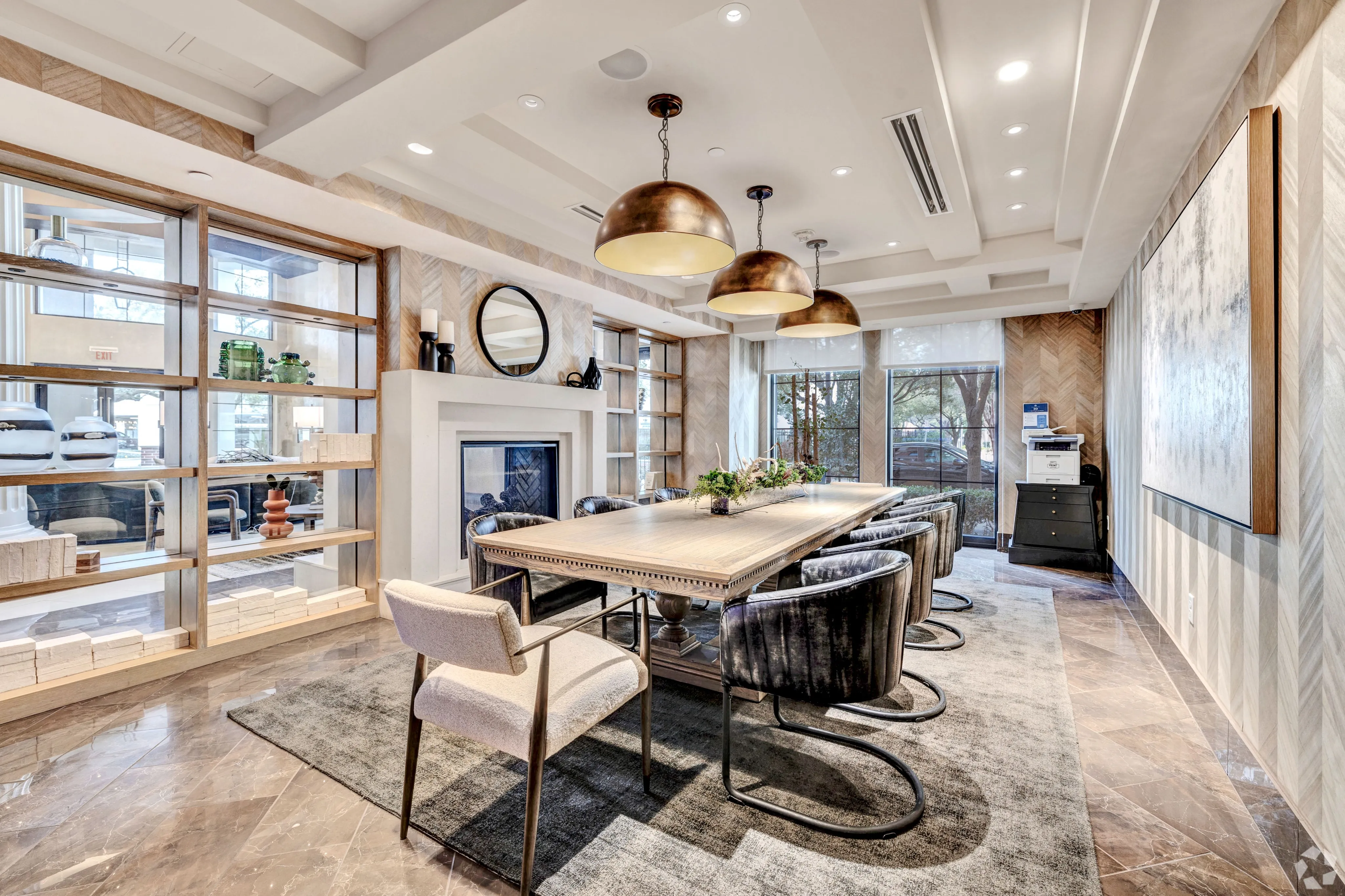 Elegant dining room with a stylish wooden table, plush velvet chairs, and modern brass pendant lights, perfect for sophisticated gatherings.