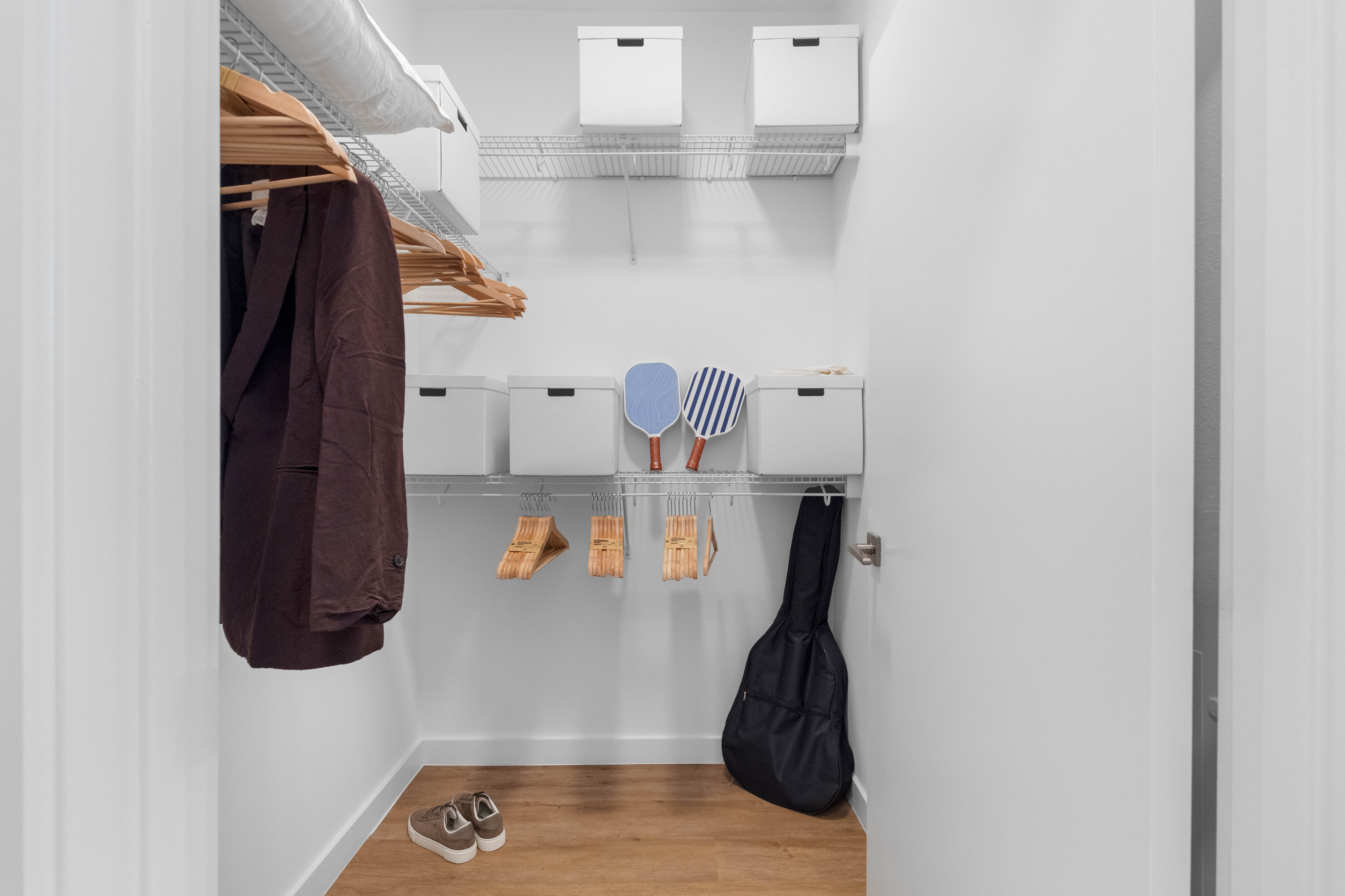Modern walk-in closet with elegant shelving, stylish storage boxes, and ample hanging space, perfect for organizing and maximizing storage.