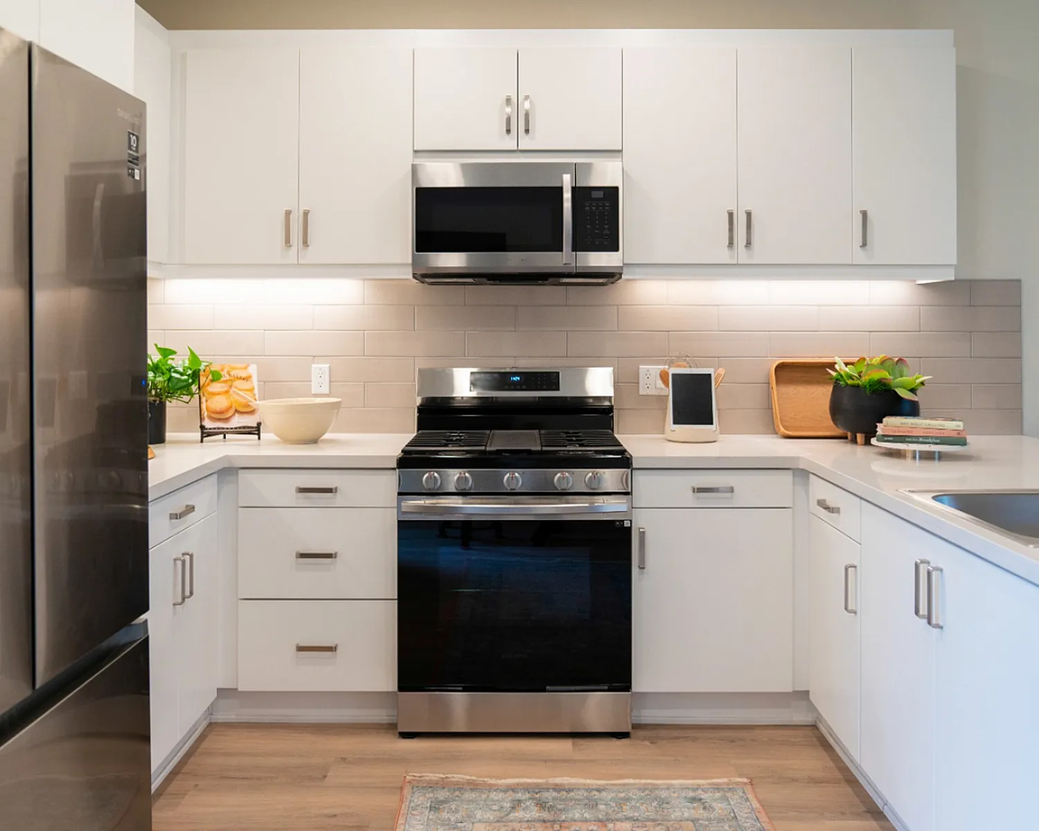 Contemporary kitchen with stainless steel appliances, white cabinets, and elegant countertops.