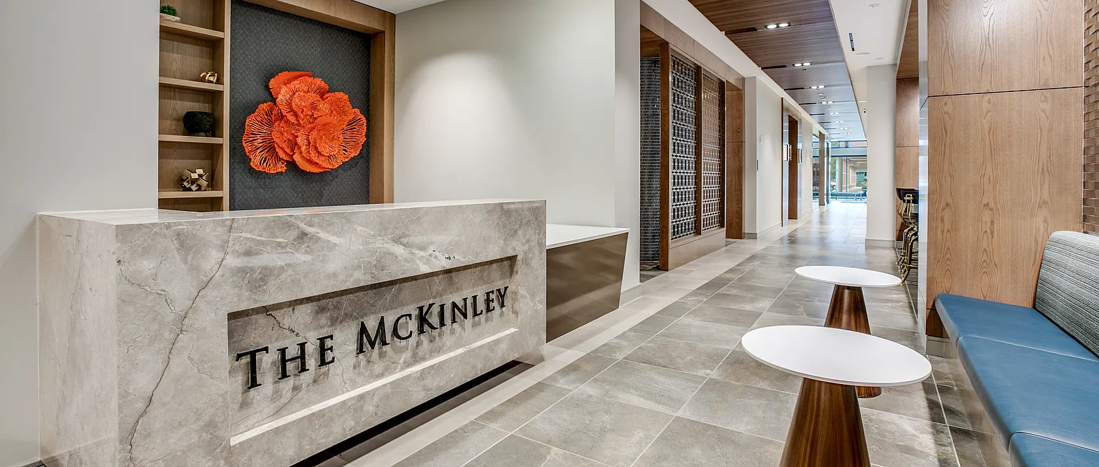 Sophisticated lobby with marble reception desk, modern decor, and warm lighting.