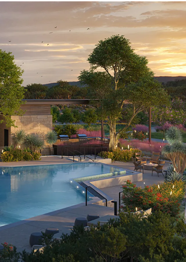 Luxurious sunset view of a modern apartment complex featuring a sparkling pool, elegant lounge chairs, and lush landscaping.