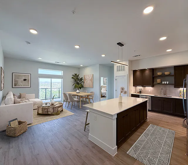 Chic open-concept apartment featuring a modern kitchen with a large island, a cozy living area, and a stylish dining space with abundant natural light.