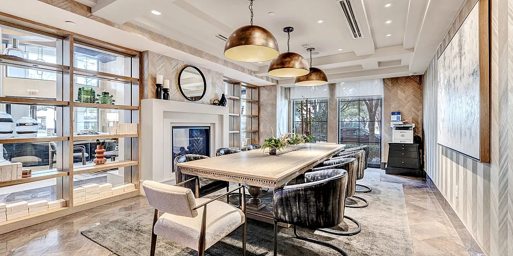 Elegant dining room with modern decor, featuring stylish lighting fixtures, a large table, comfortable chairs, and a cozy fireplace, perfect for entertaining.