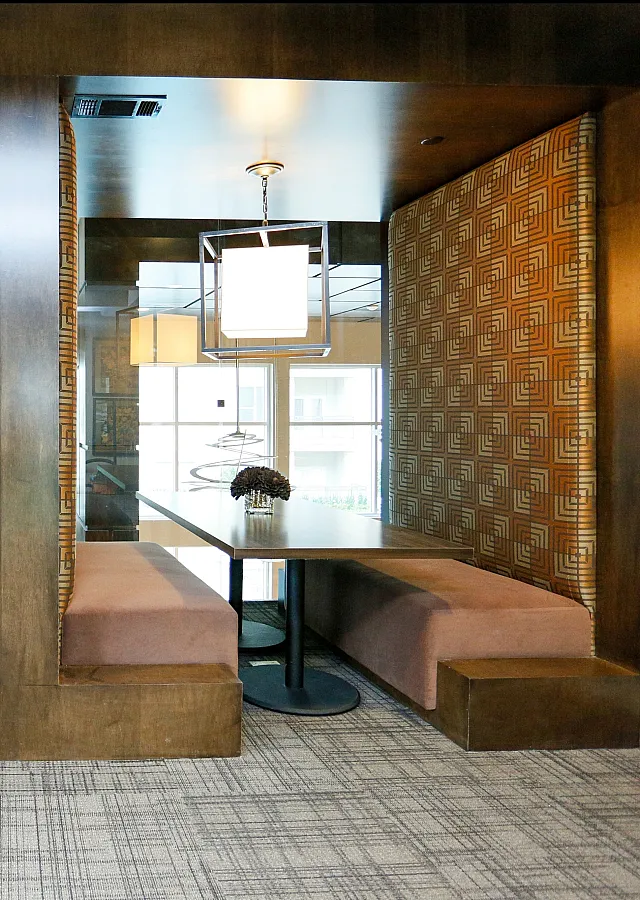 Modern communal seating area with stylish wooden booths and elegant lighting, perfect for social dining or casual meetings.