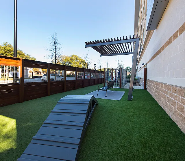 Chic outdoor space featuring a cozy seating area and lush artificial grass, perfect for relaxation.