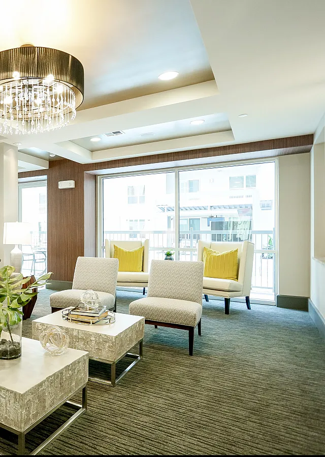 Luxurious lounge with modern sofas, elegant decor, and stunning chandelier, offering a sophisticated living experience.