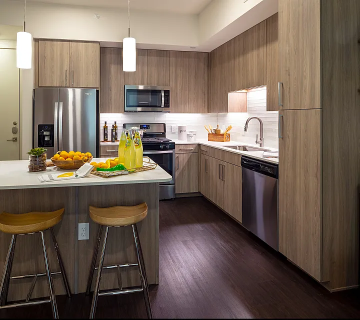 Contemporary kitchen with sleek wood cabinetry, stainless steel appliances, and a stylish island countertop with bar seating.