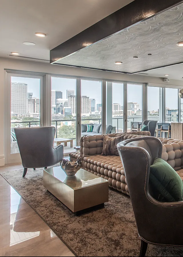 Luxurious open-concept living space with modern furniture, floor-to-ceiling windows, and city skyline views.