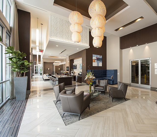 Luxurious lobby interior featuring modern design with elegant lighting, plush blue seating, and chic decor accents.