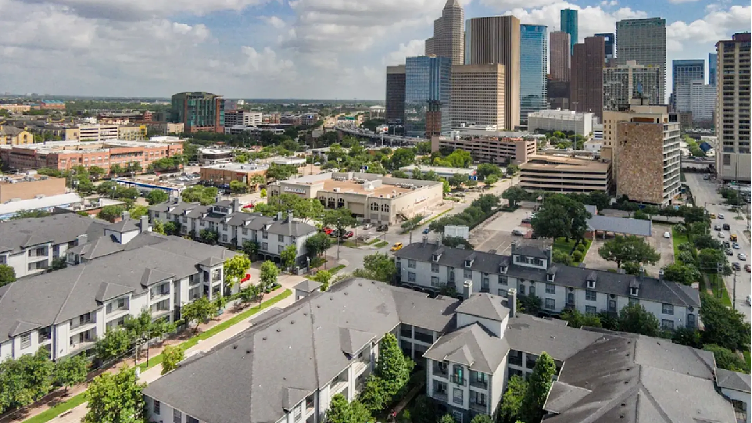Luxurious apartment complex with a stunning pool area, nestled in the vibrant city skyline, offering modern urban living.