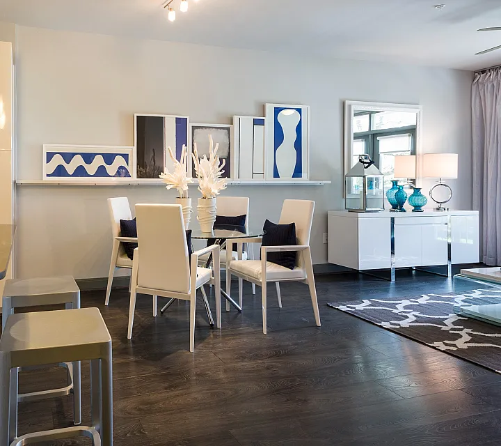 Modern apartment interior featuring a sleek open-plan kitchen with stylish bar seating and a chic dining area, complemented by contemporary artwork and elegant lighting.