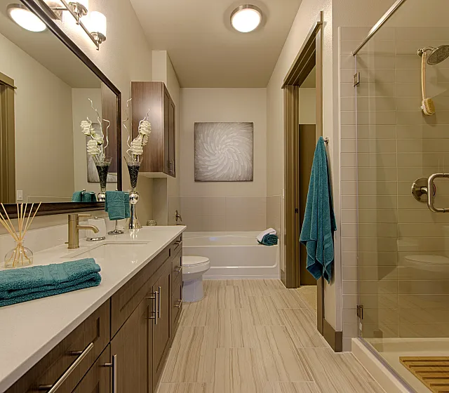 Elegant modern bathroom featuring sleek cabinetry, glass-enclosed shower, and luxurious vanity with stylish decor.