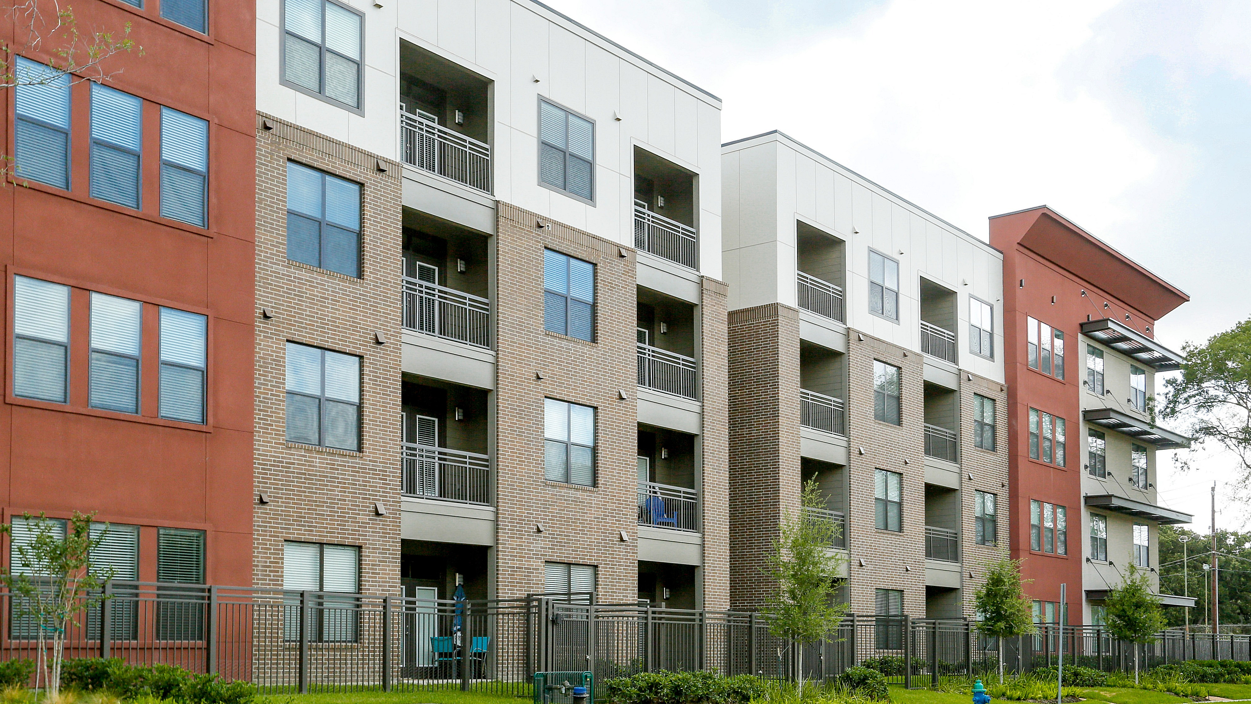 Contemporary apartment building with modern design, featuring stylish balconies and beautifully landscaped surroundings.