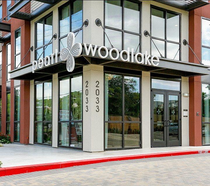 Modern apartment complex entry at Pearl Woodlake, showcasing sleek architectural design and welcoming environment.