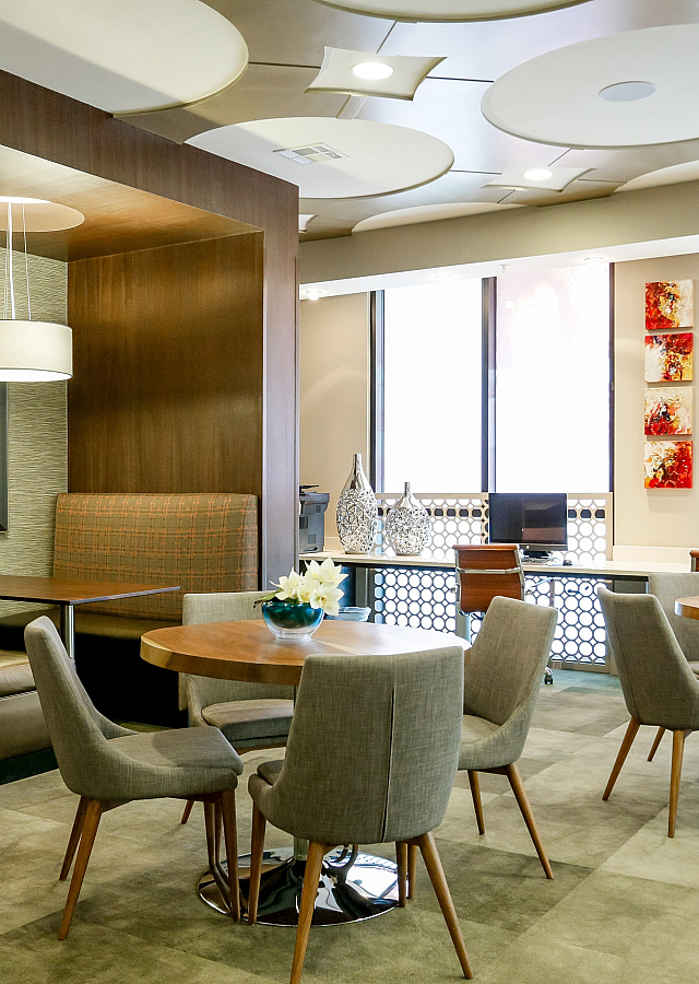 Chic and modern communal space with stylish seating, elegant lighting, and ample workspace.