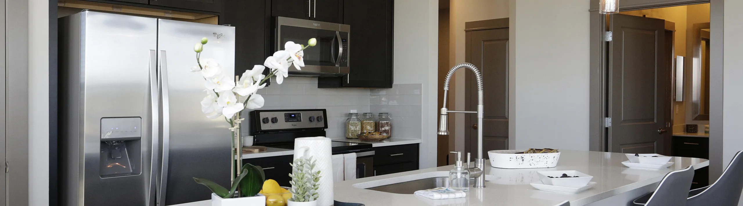 Modern kitchen with sleek stainless appliances, chic pendant lighting, and a stylish island with comfortable seating.