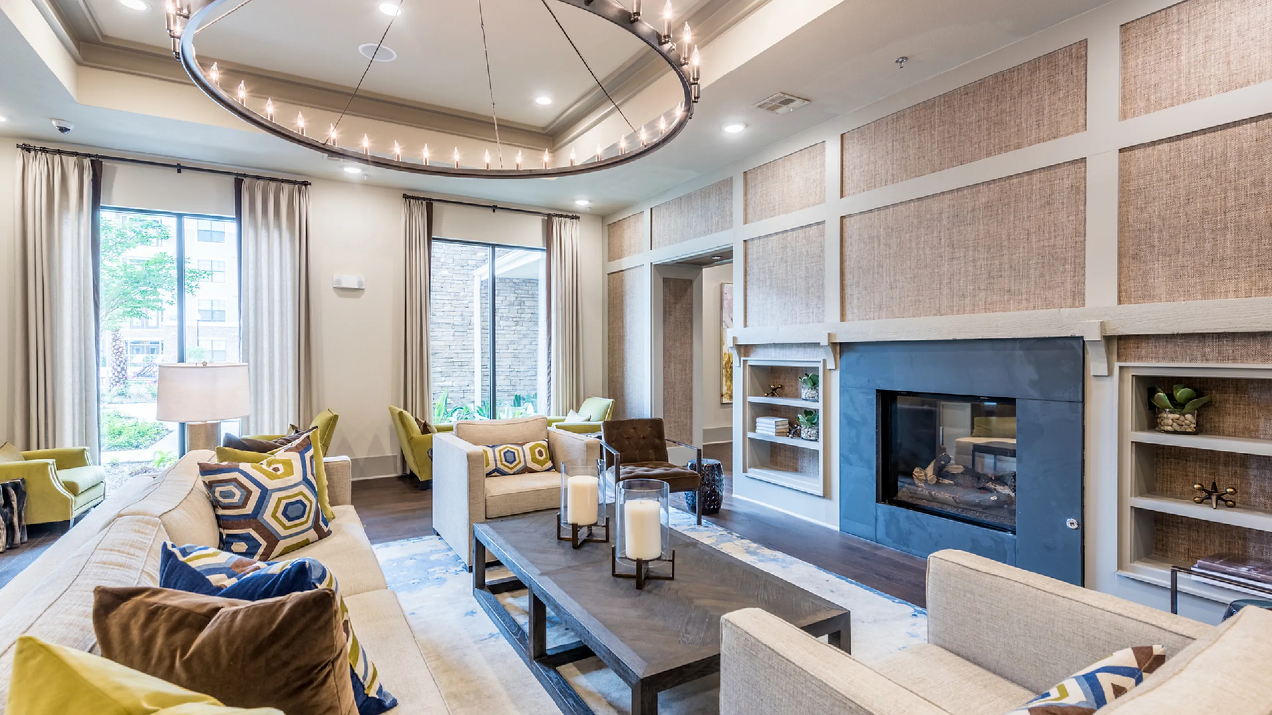Elegant living room with modern decor, featuring a cozy fireplace, large windows for natural light, and stylish furnishings.