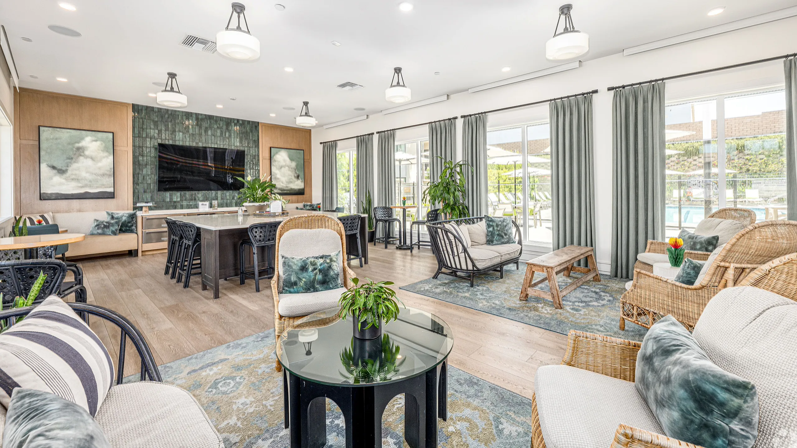 Inviting communal lounge featuring elegant seating, abundant natural light, and modern decor with a view of the pool area.