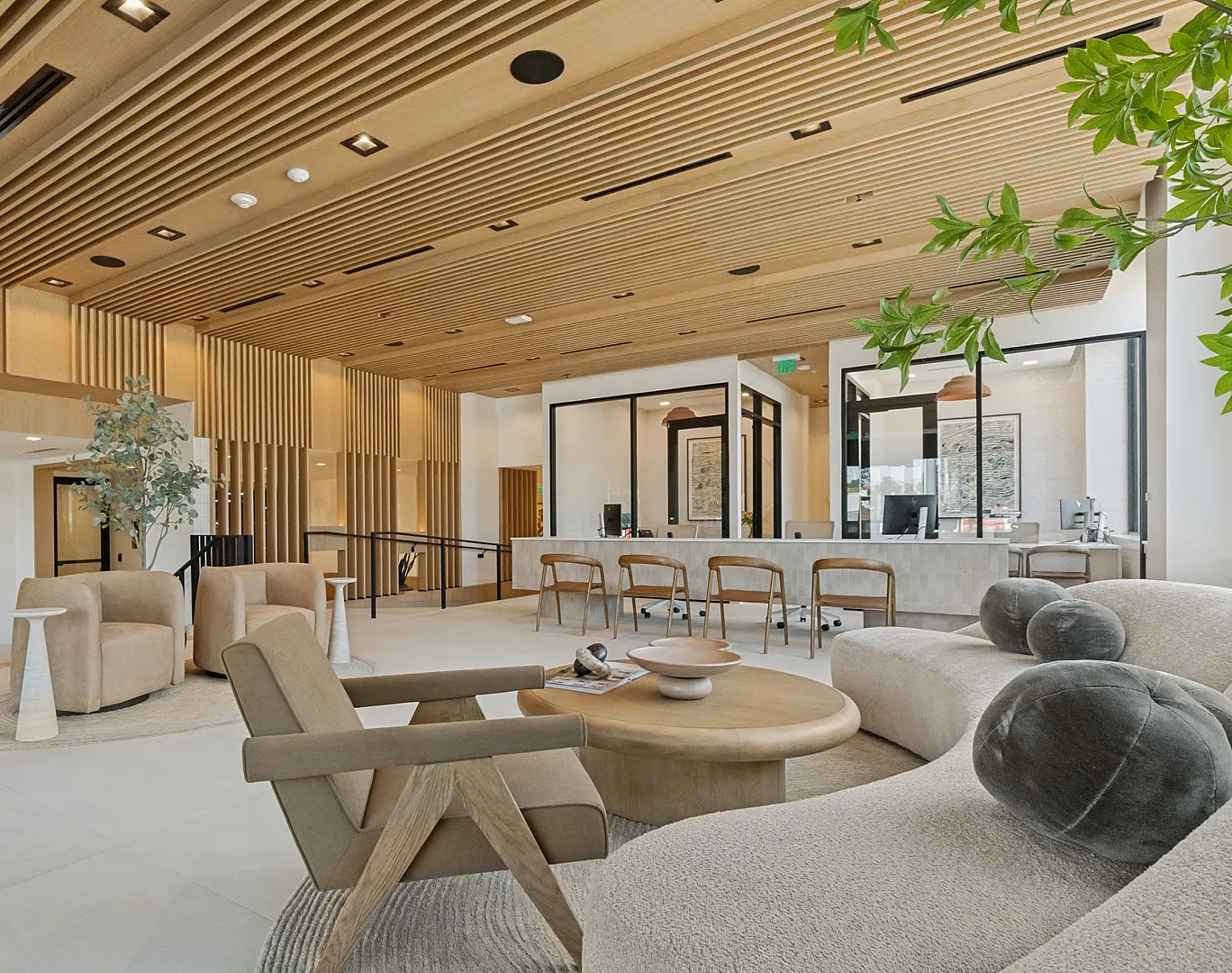 Elegant modern lounge with cozy seating, warm wood accents, and natural decor, perfect for relaxation and social gatherings.
