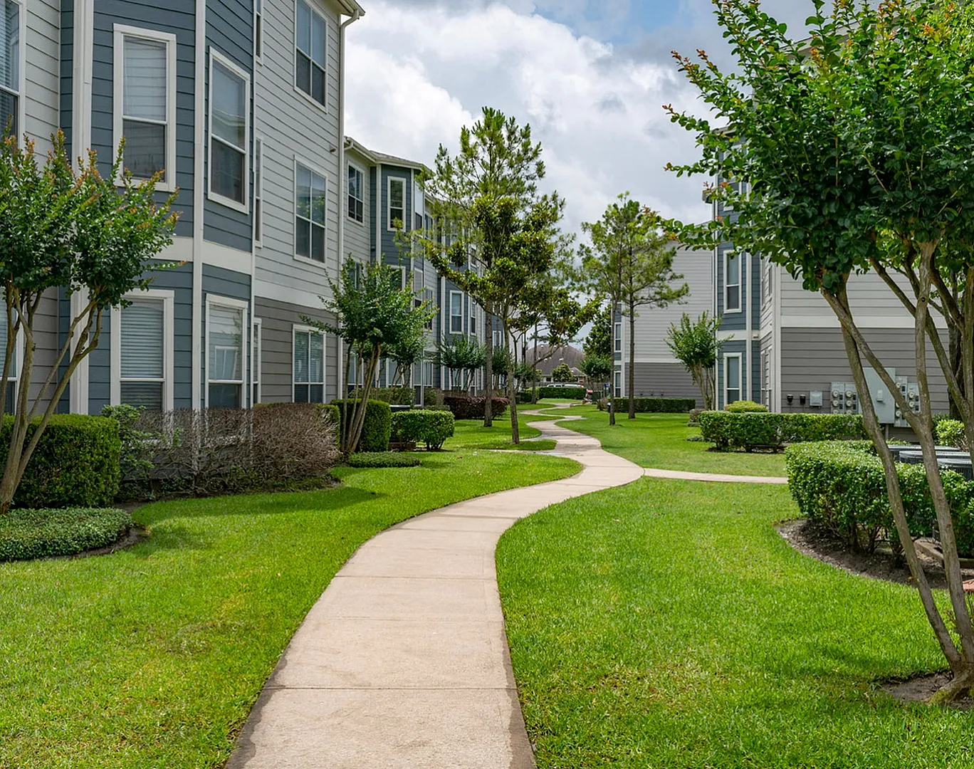 Courtyard walkway with lawn, shade trees and three-story buildings, Houston, TX