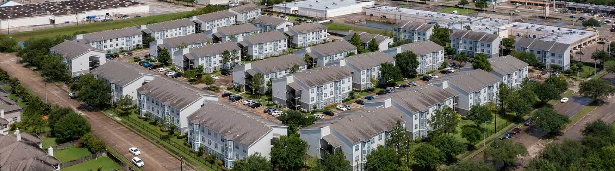 Aerial of apartment community, parking and surrounding neighborhood, Houston, TX