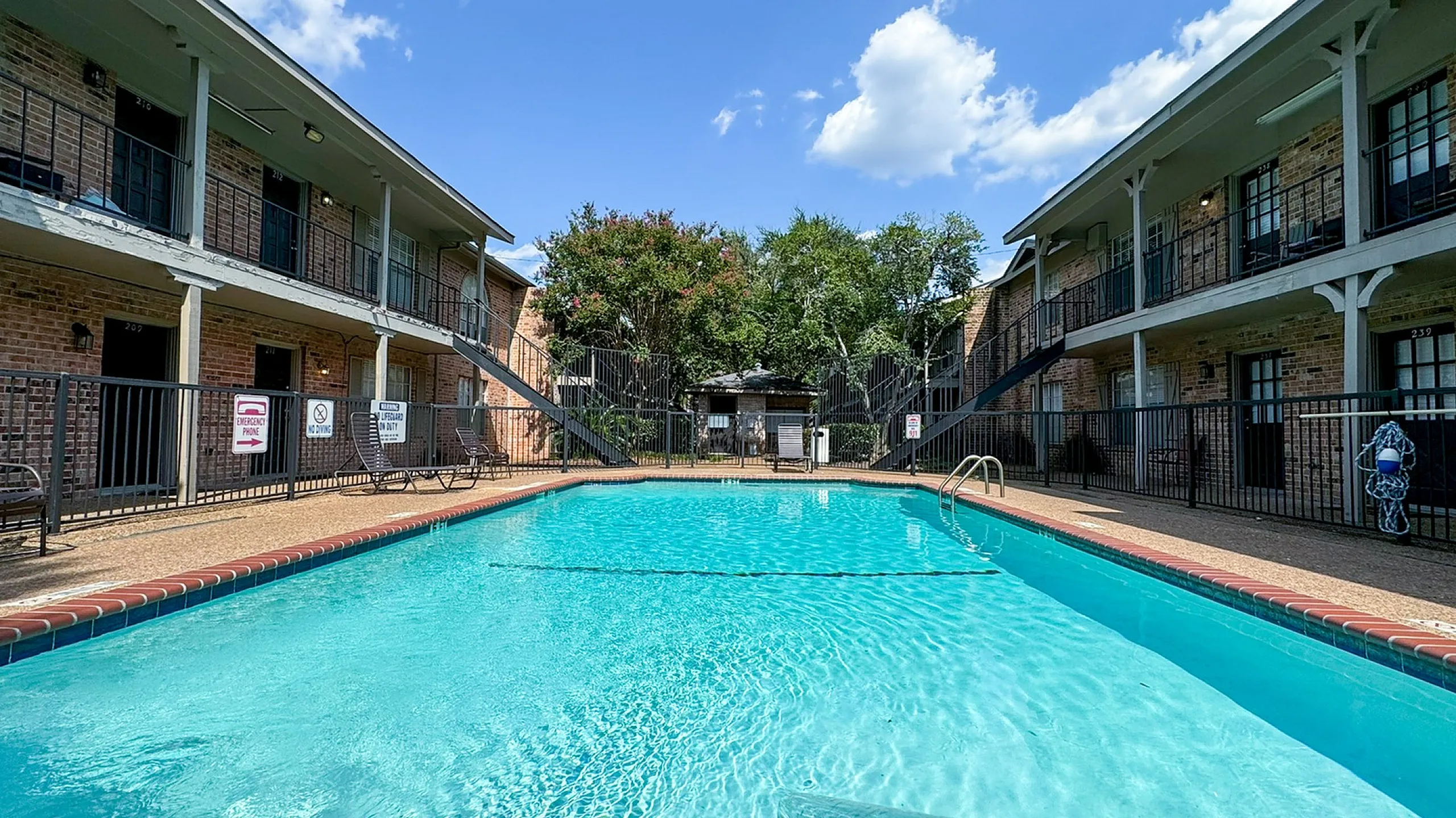 Courtyard pool with brick deck, two-story balconies and shade trees, Memorial City, Houston TX